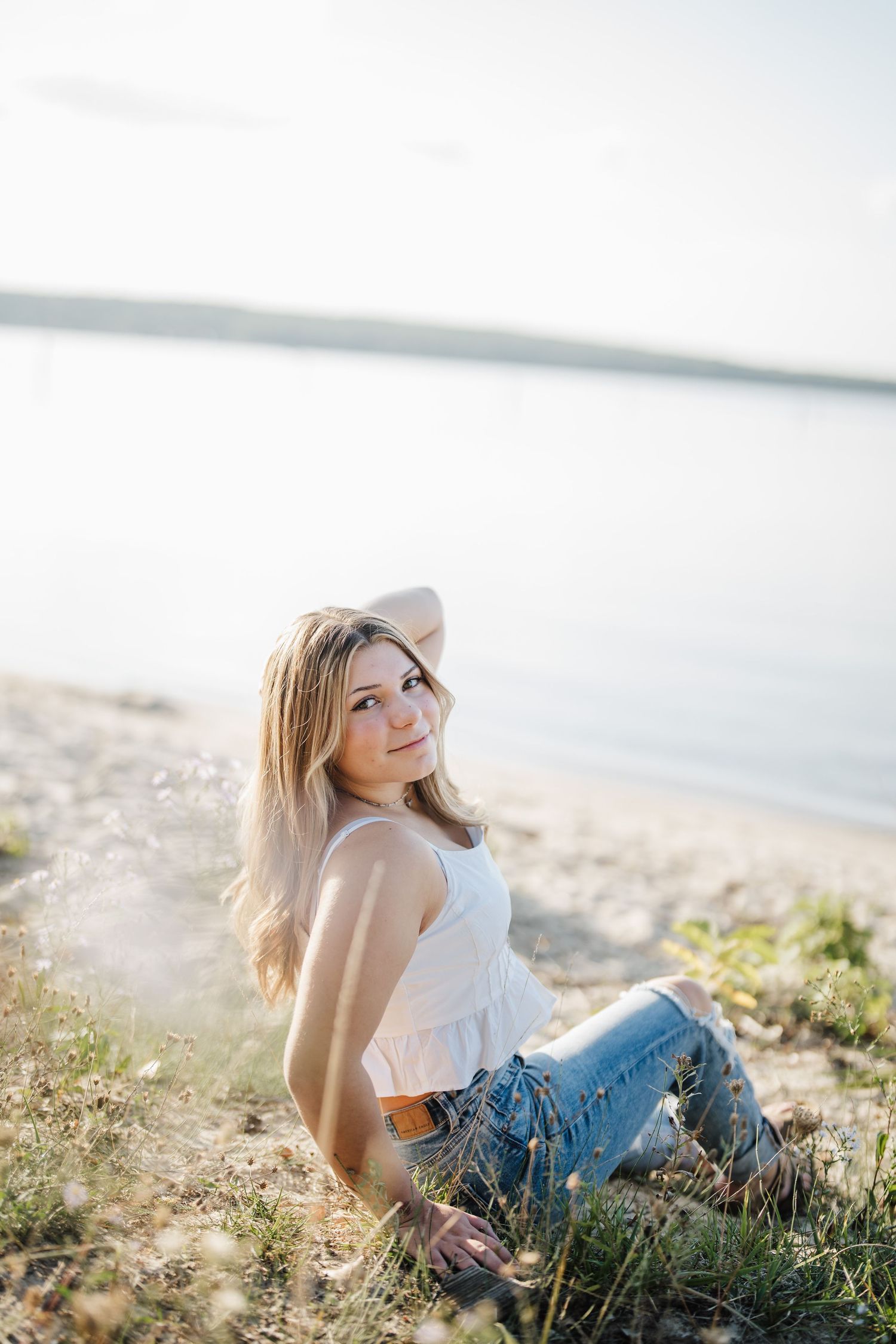 Ethereal seaside photoshoot with soft sunlight illuminating the coastal landscape.