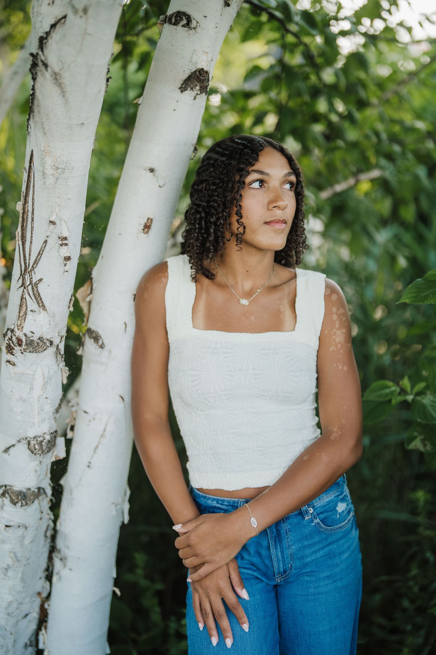 Artistic portraits against white birch trees showing someone in casual attire with natural lighting and foliage.