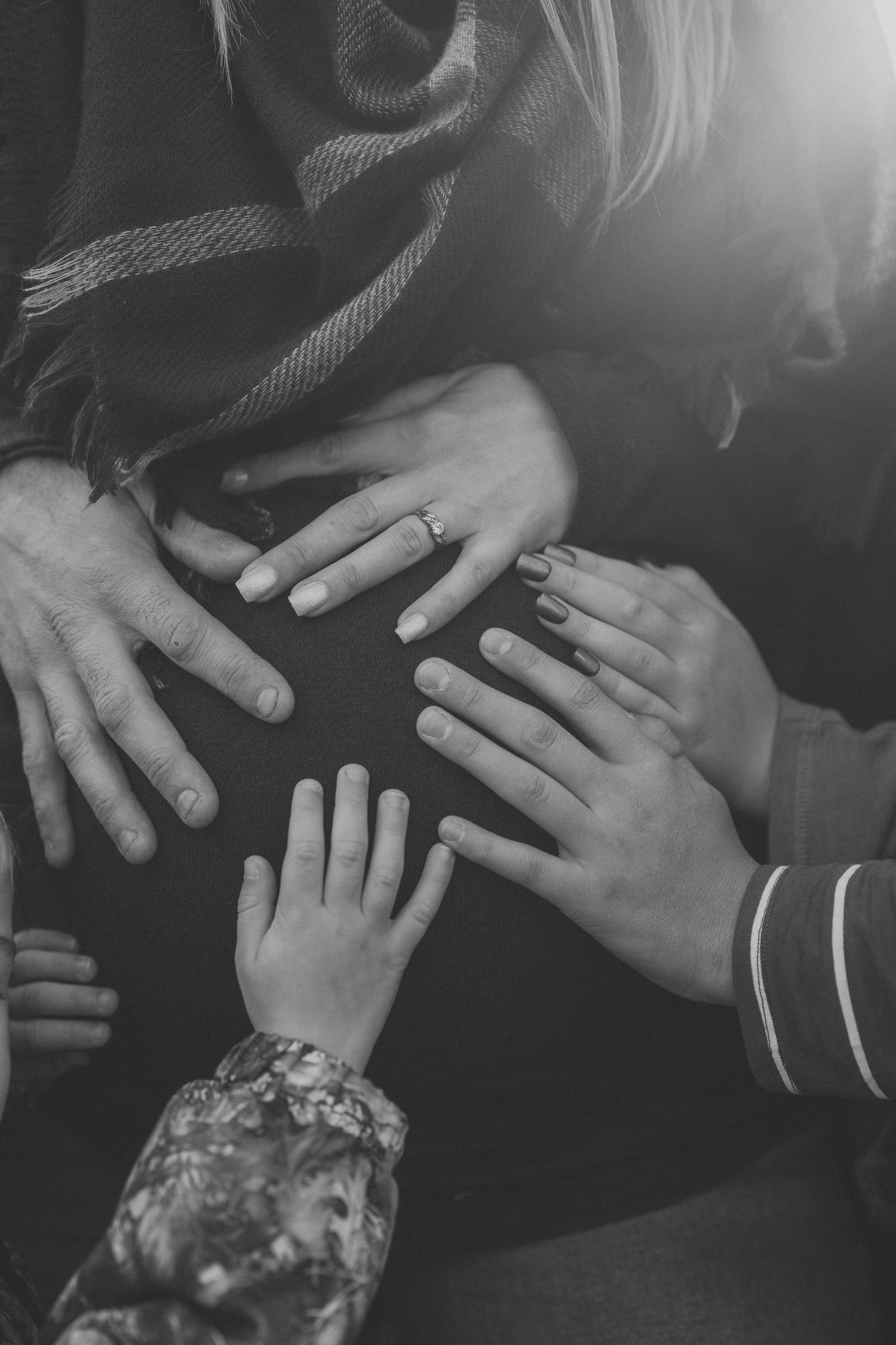Multiple black and white images showing hands with wedding rings touching and intertwining in an intimate sequence.