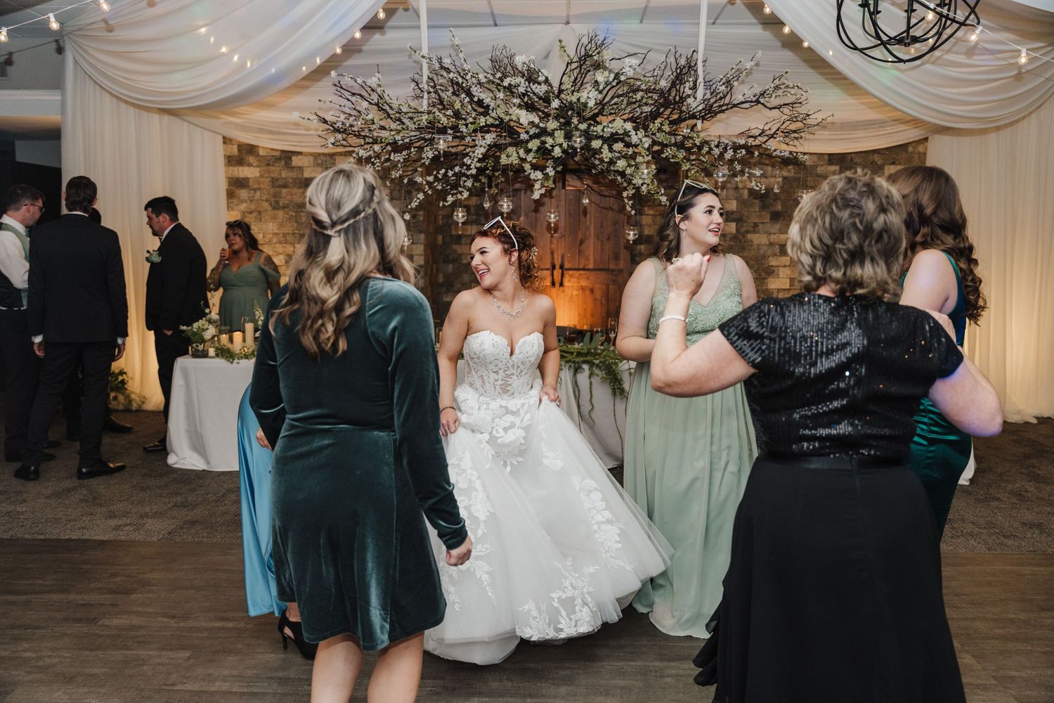 Wedding reception dance floor scene with guests in formal attire.