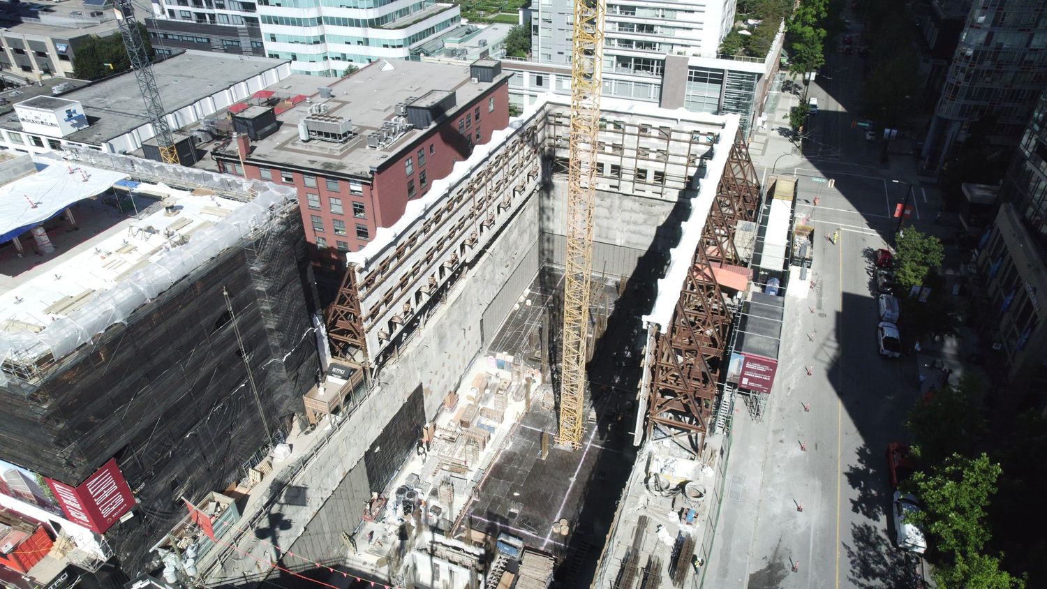 Panoramic aerial view of urban construction site surrounded by modern buildings and streets.