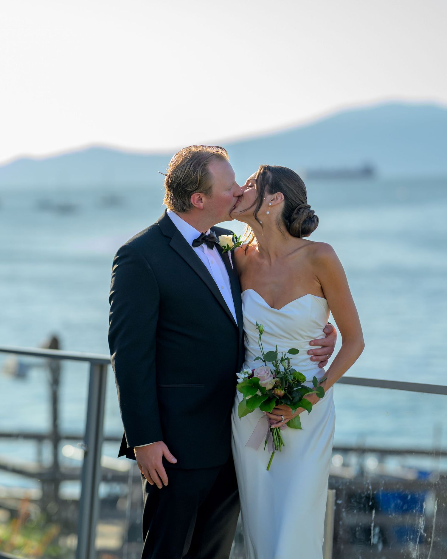 Romantic wedding portraits captured on oceanfront deck at sunset.