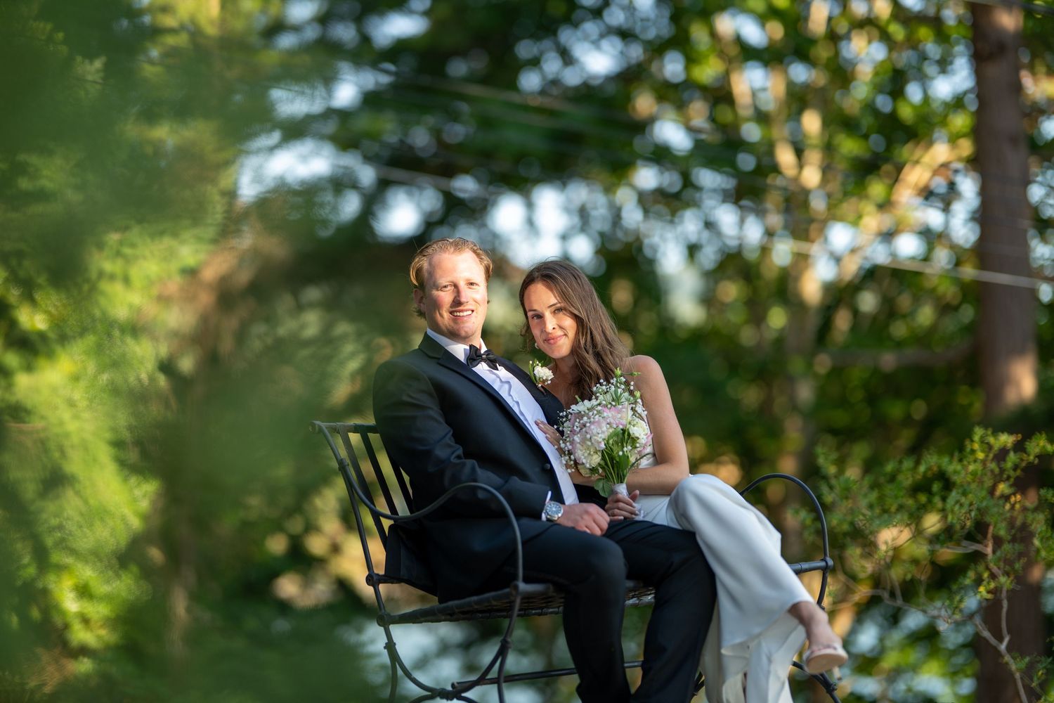 Wedding couple shares intimate moments in a lush green garden setting during golden hour.