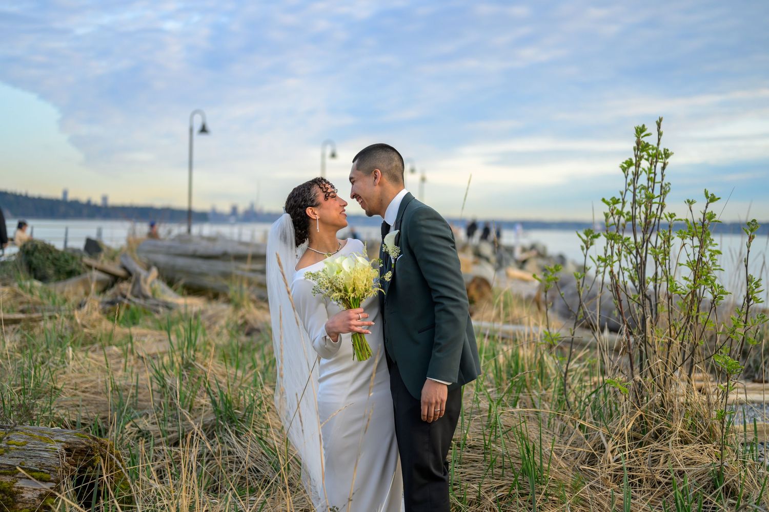 Couple sharing intimate moments along a coastal path during sunset.