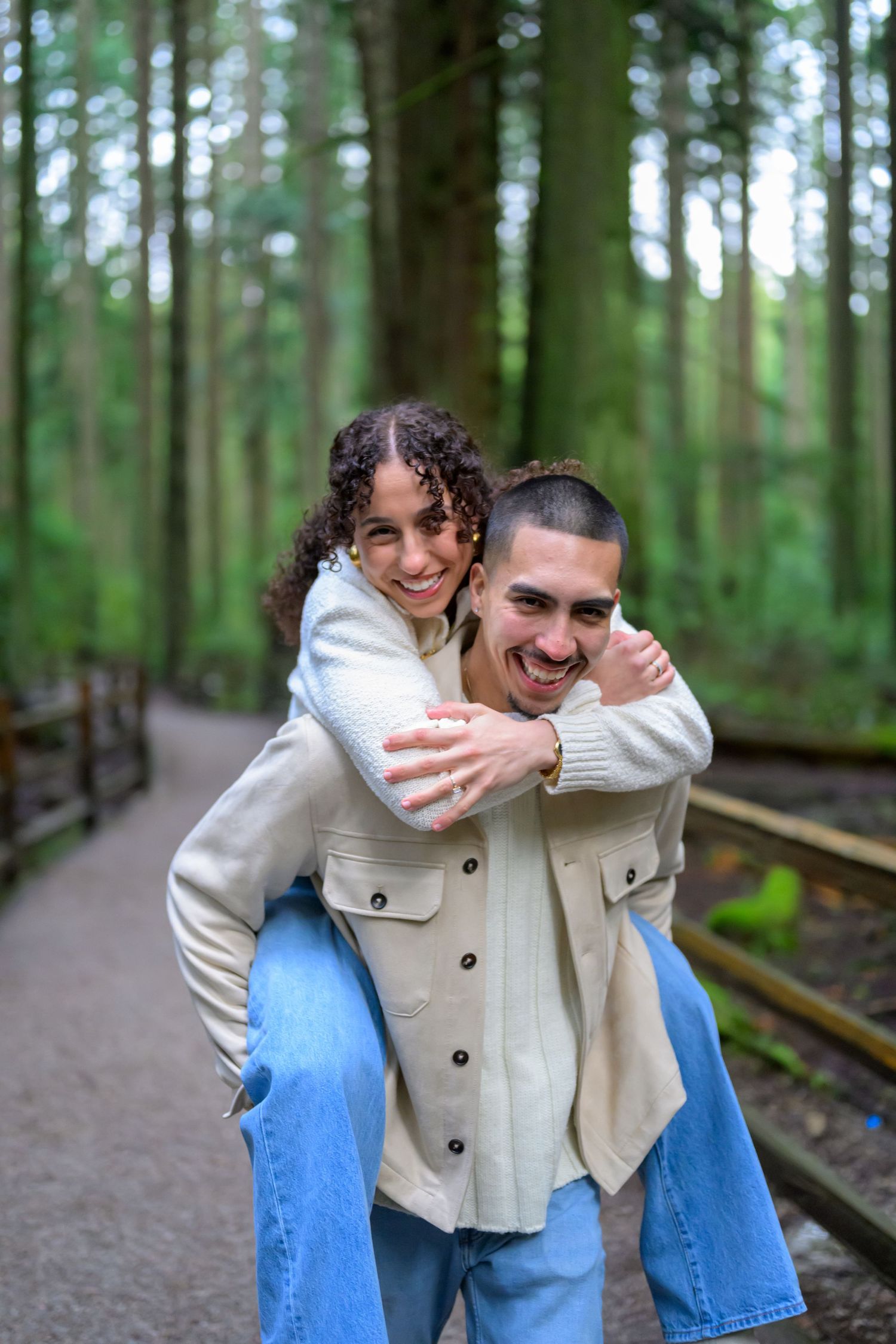 Playful piggyback ride on a wooden boardwalk through a pine forest.