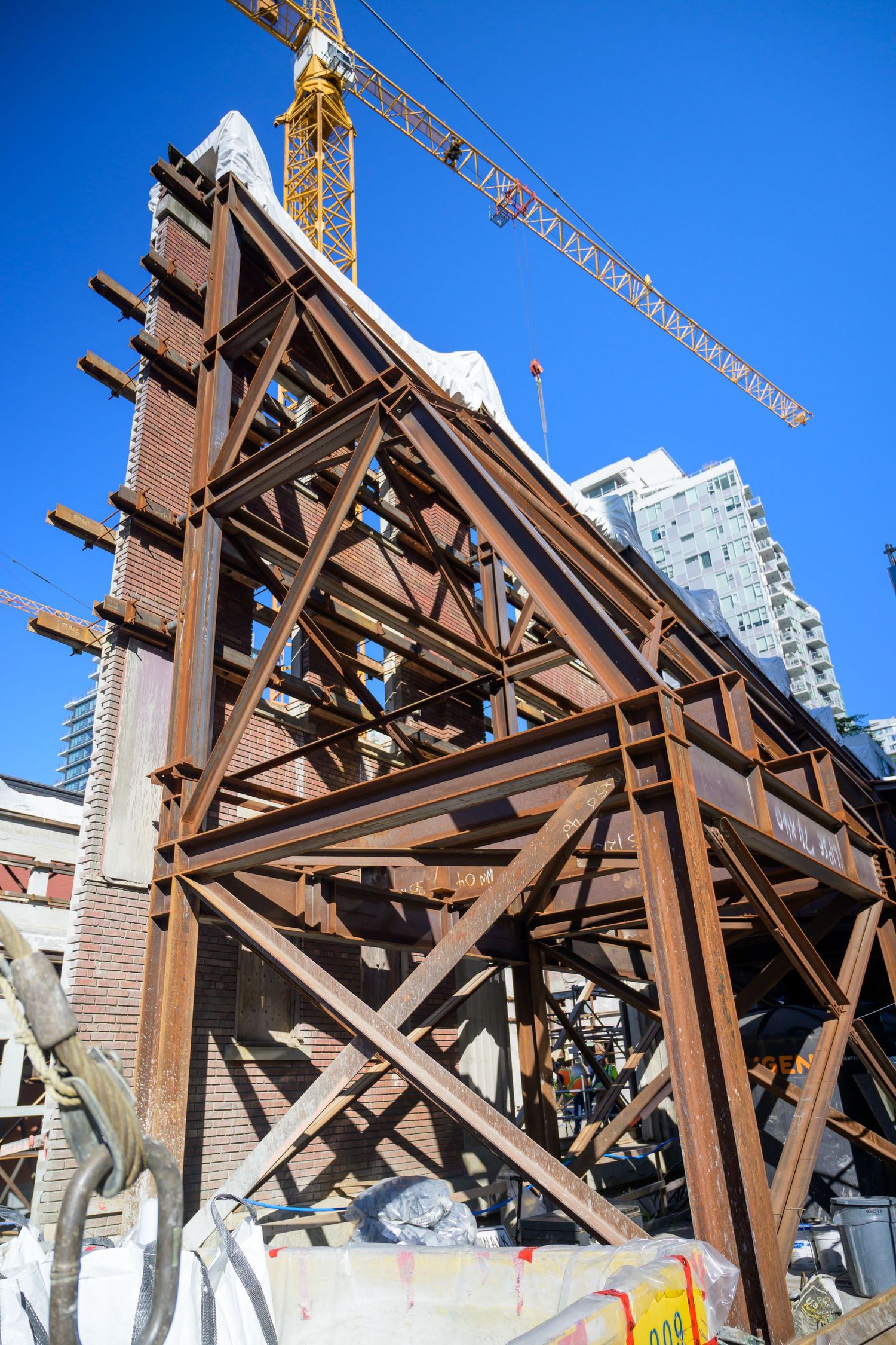 Rustic brown steel framework and support beams against bright blue sky during construction.