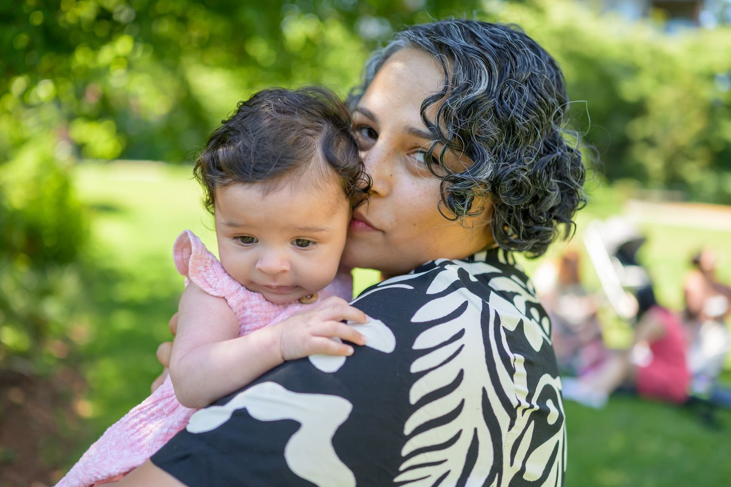Tender family moments captured in a series of outdoor portraits with natural greenery.