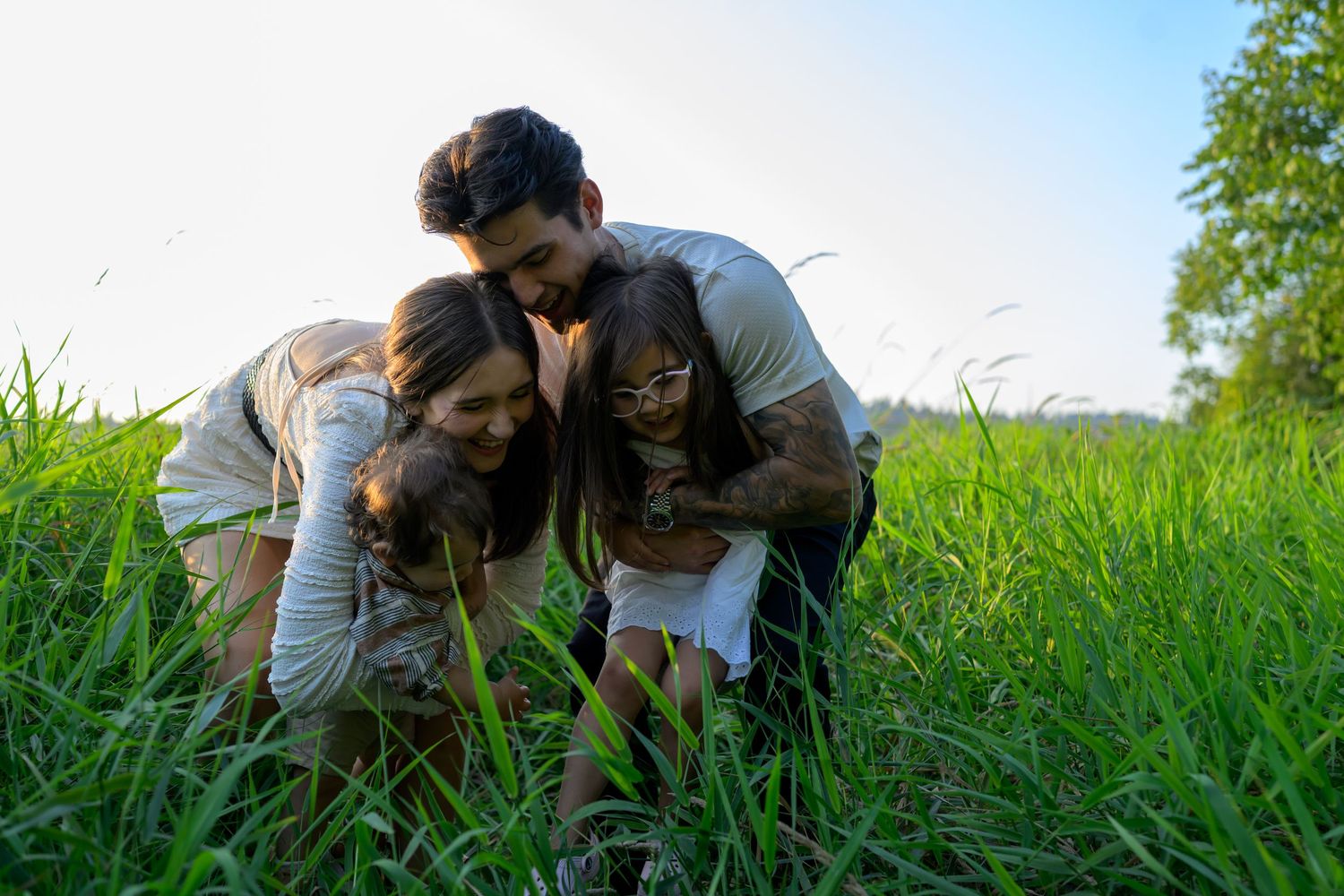 People playfully interacting in a green meadow on a bright day.