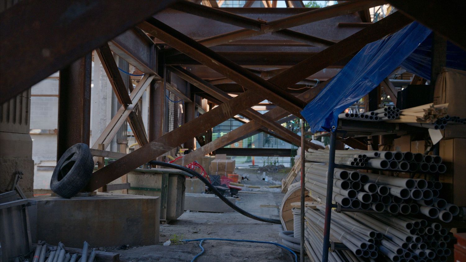Dark interior construction shot showing structural beams and temporary lighting.
