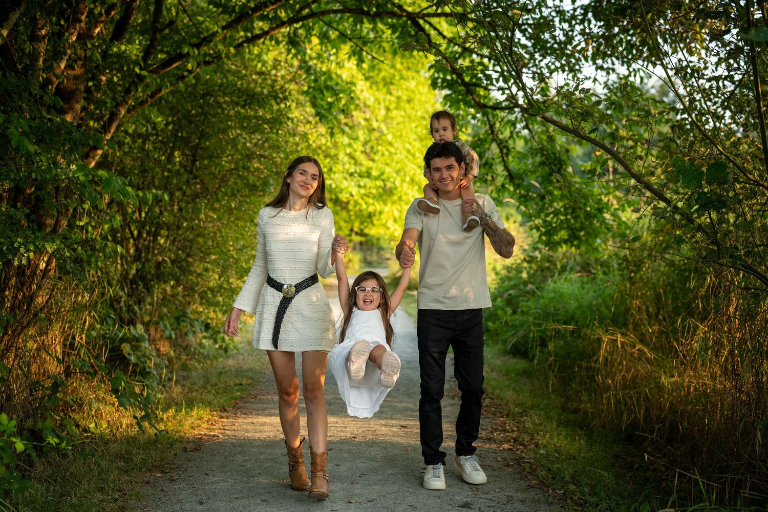 Family walking along a nature trail surrounded by green foliage.