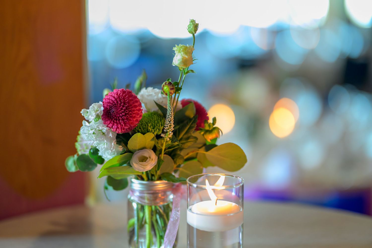 Romantic table settings with floral centerpieces and candlelight for wedding reception.
