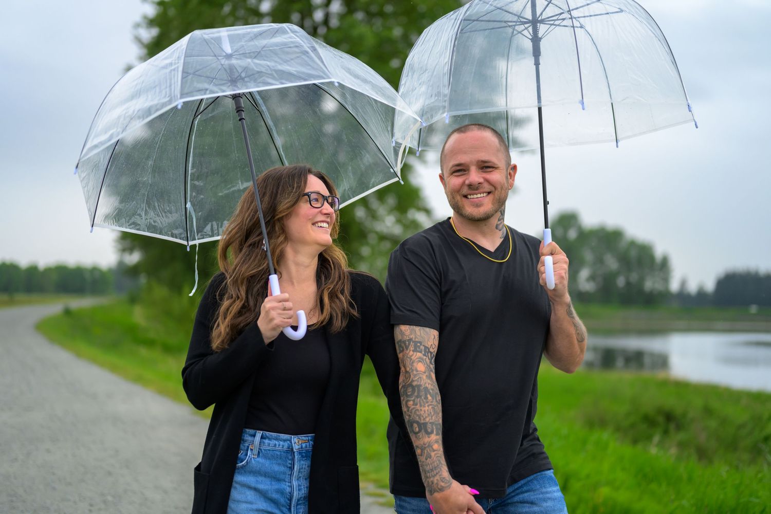 Couple walking together under a clear umbrella on a rainy day.