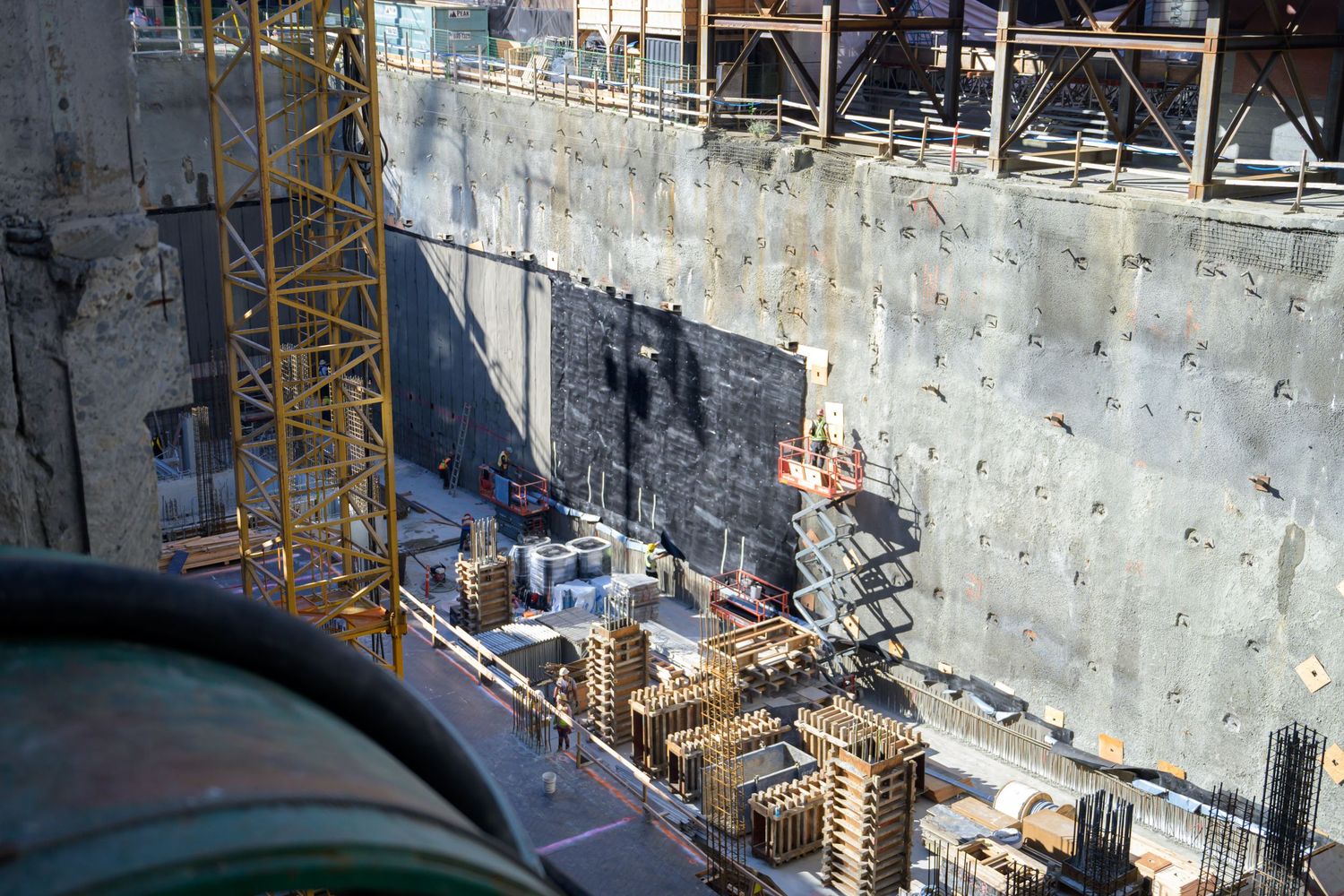 Construction site with concrete walls and scaffolding viewed from above.
