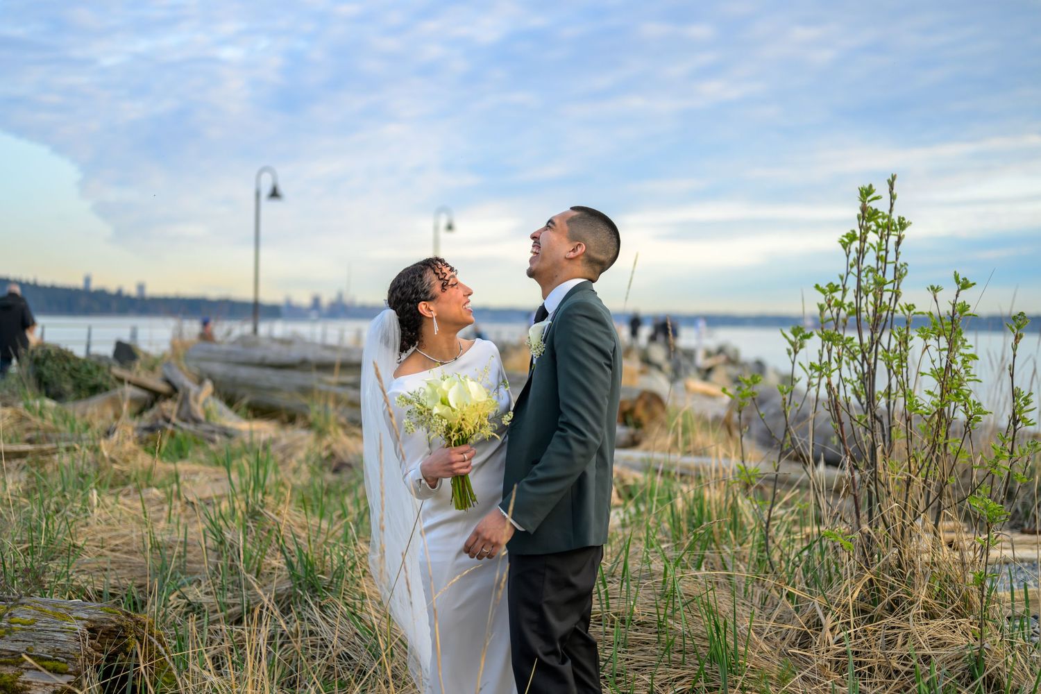 Newlywed couple sharing romantic moment on beach during sunset.