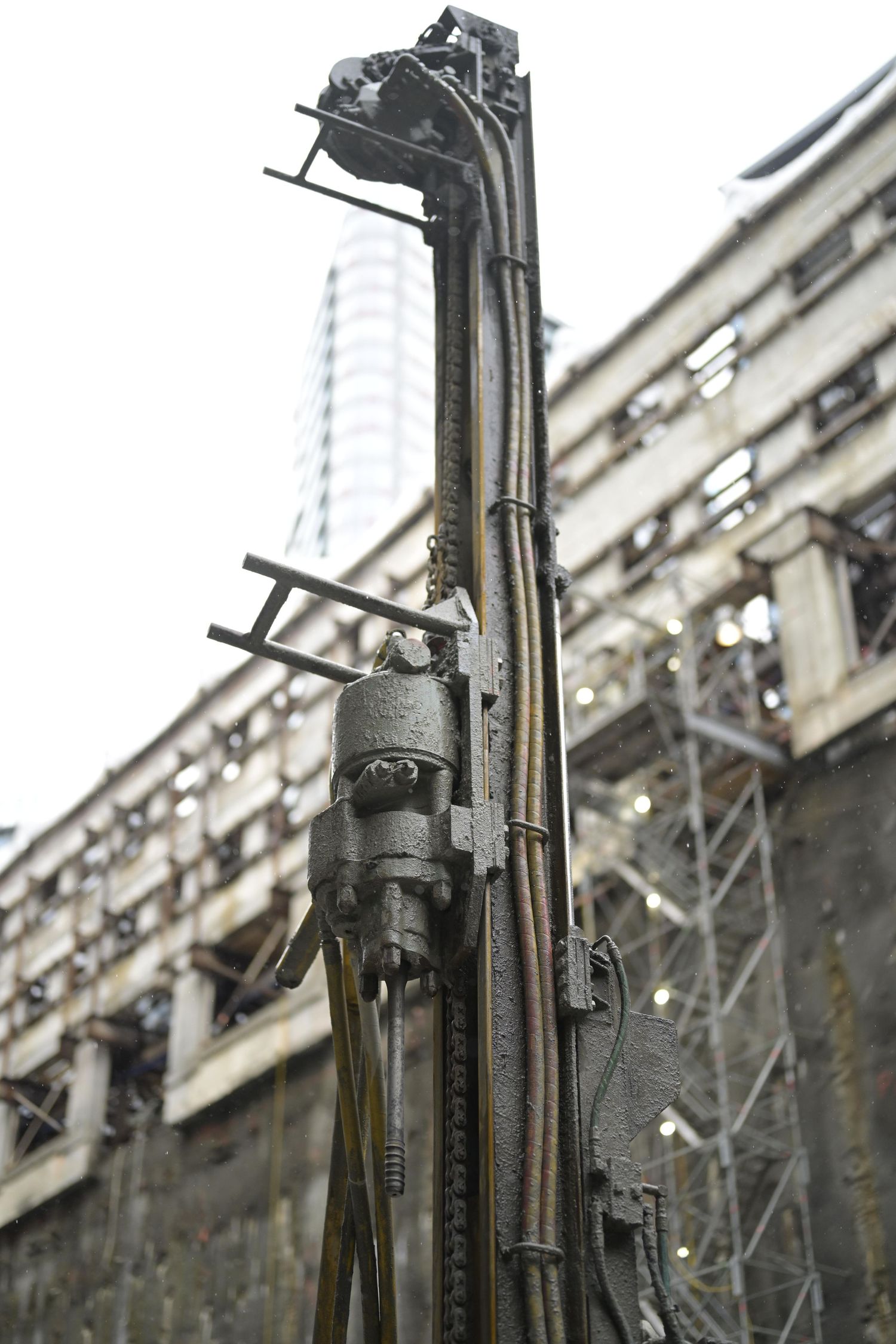 Industrial machinery and metal structures against an urban building backdrop.