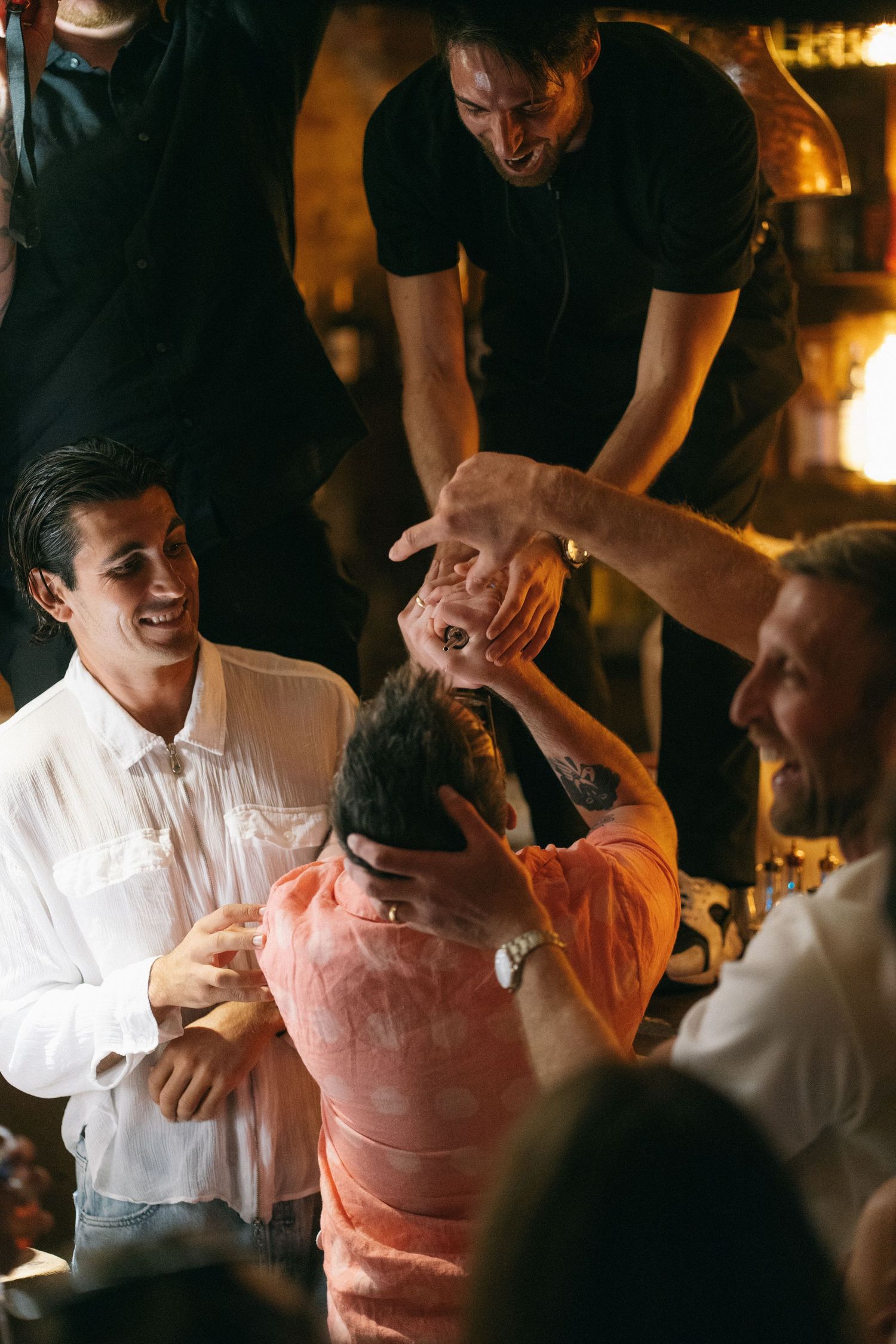 Group of friends laughing and celebrating together at a lively indoor party.