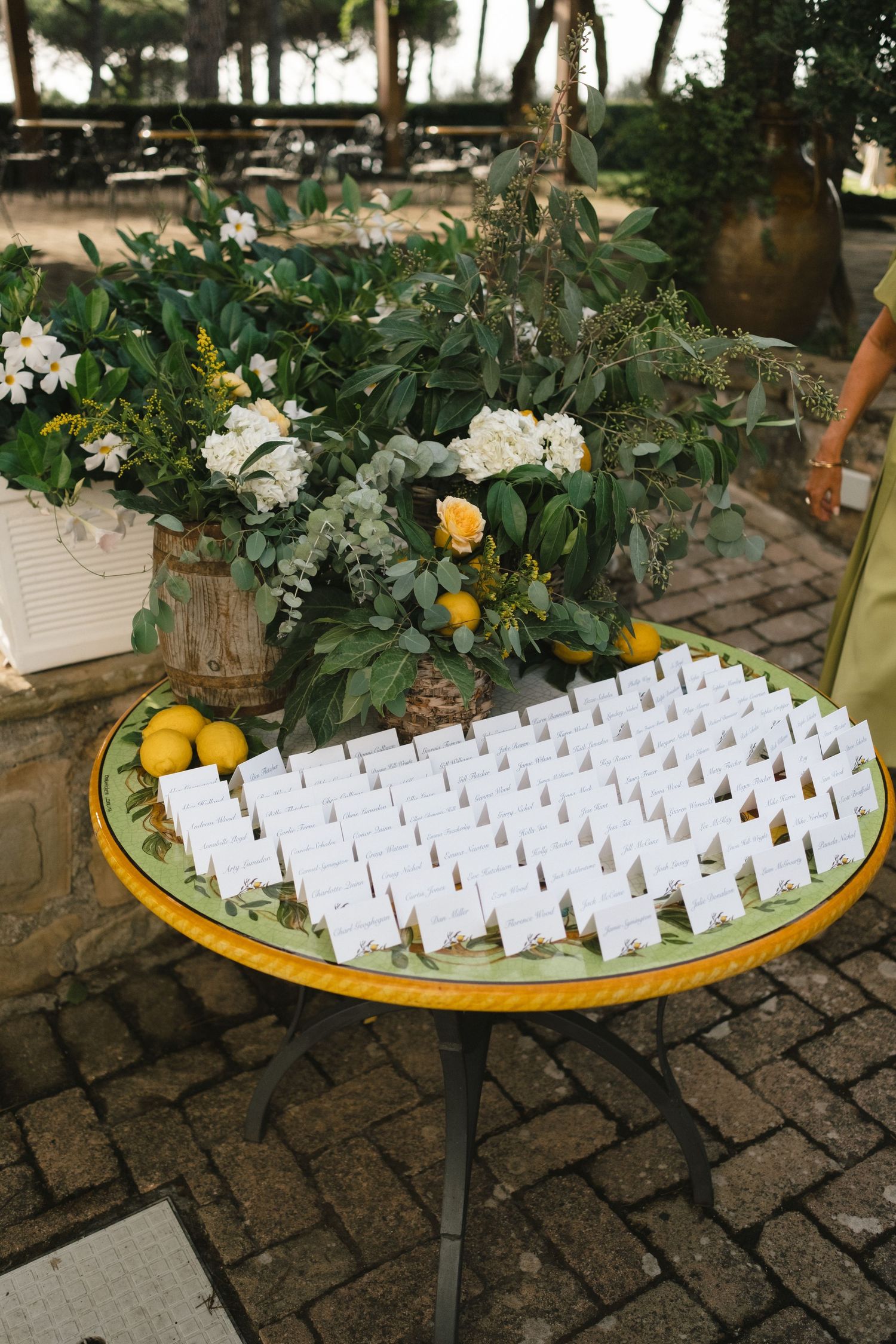 Elegant wedding escort card table decorated with lemons, white hydrangeas, and lush greenery.