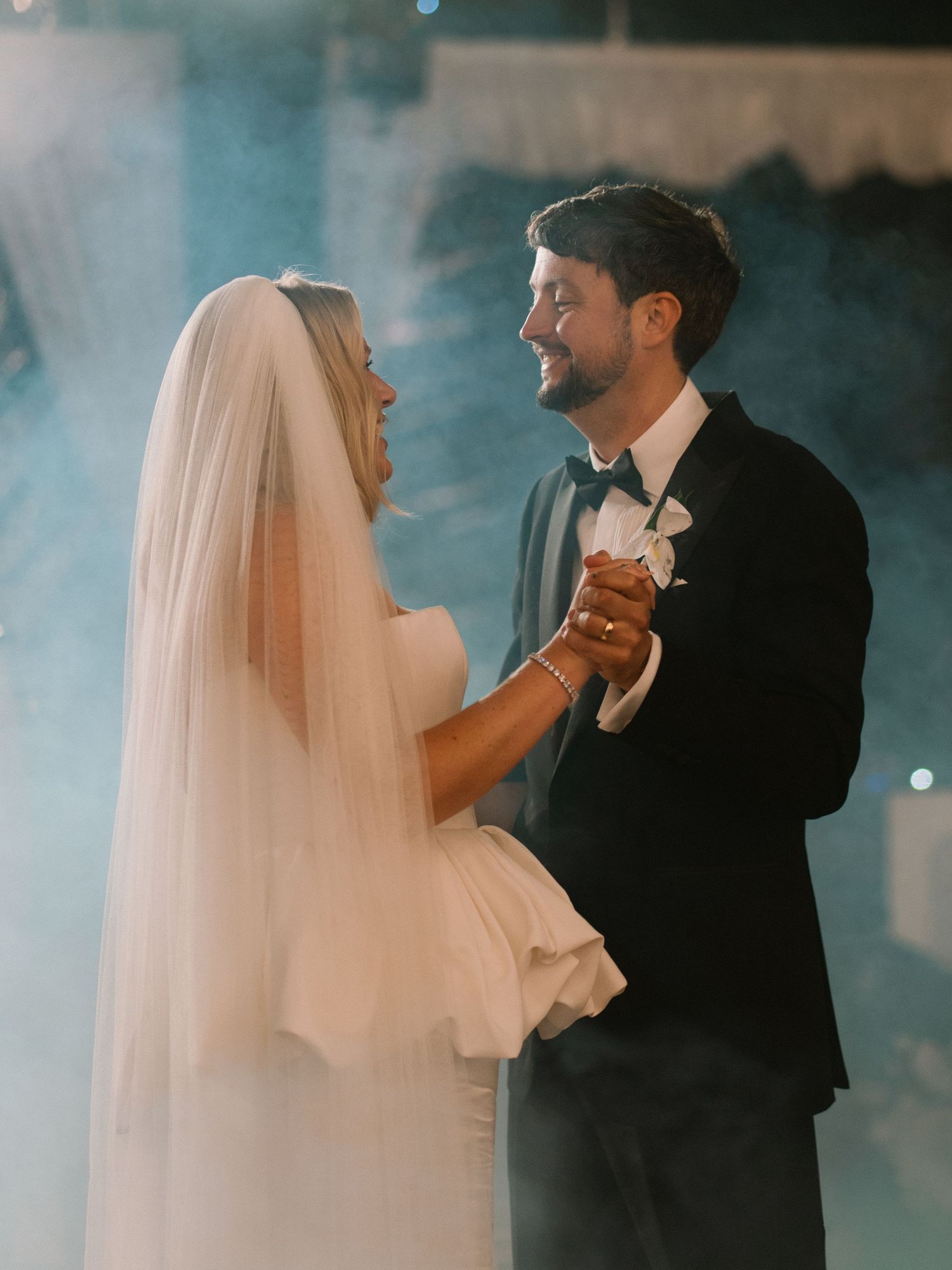 Bride and groom sharing an intimate first dance surrounded by romantic fog at their wedding.