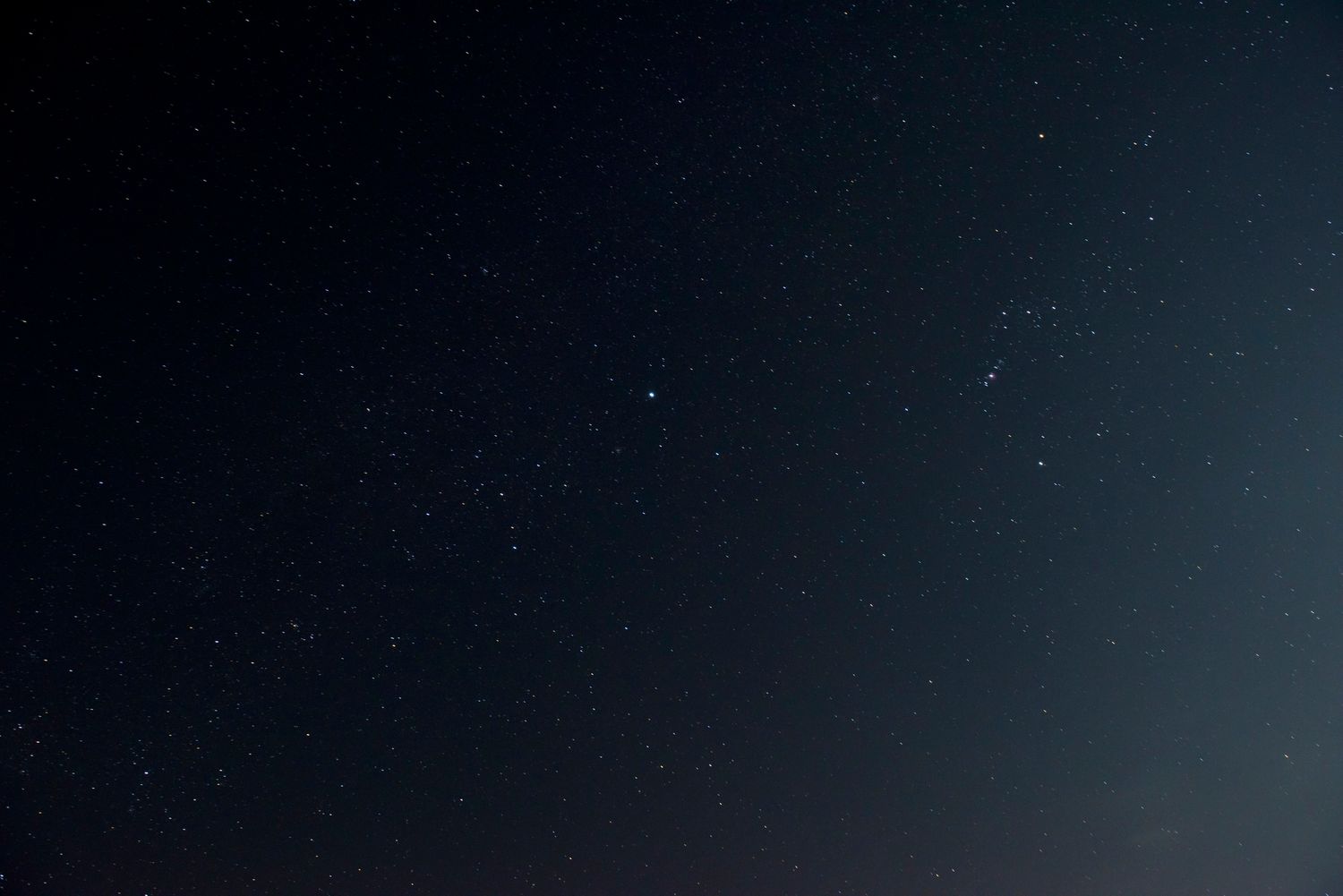 A stunning night sky filled with stars and a bright meteor streak captured in a long exposure photograph.
