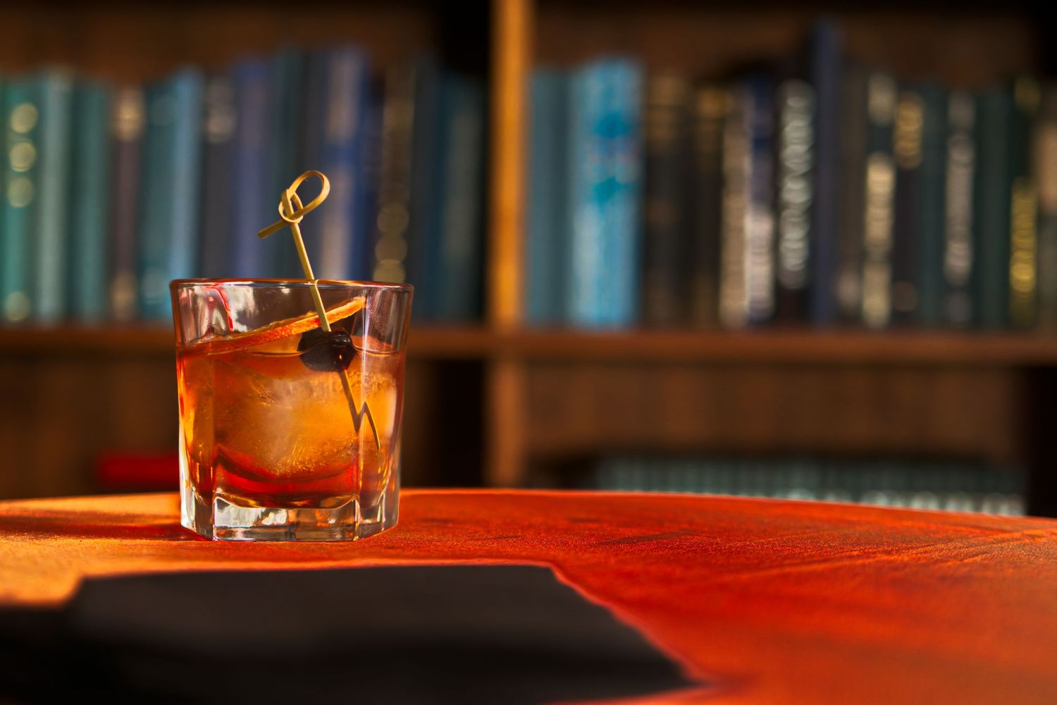 Library photo of an old fashioned drink on a table with a black cloth