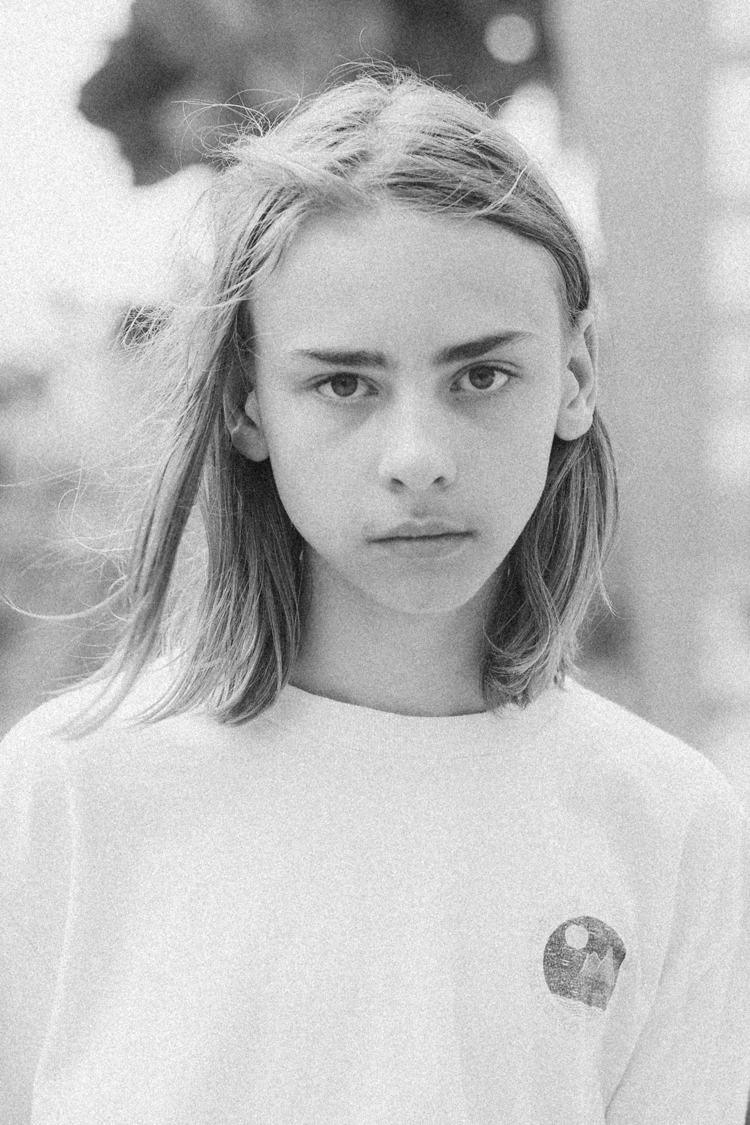 Black and white portrait of a young blonde teenager wearing a white t-shirt.