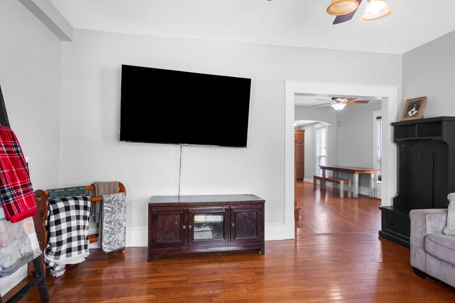 Modern living room with white walls, hardwood floors and mounted TV.