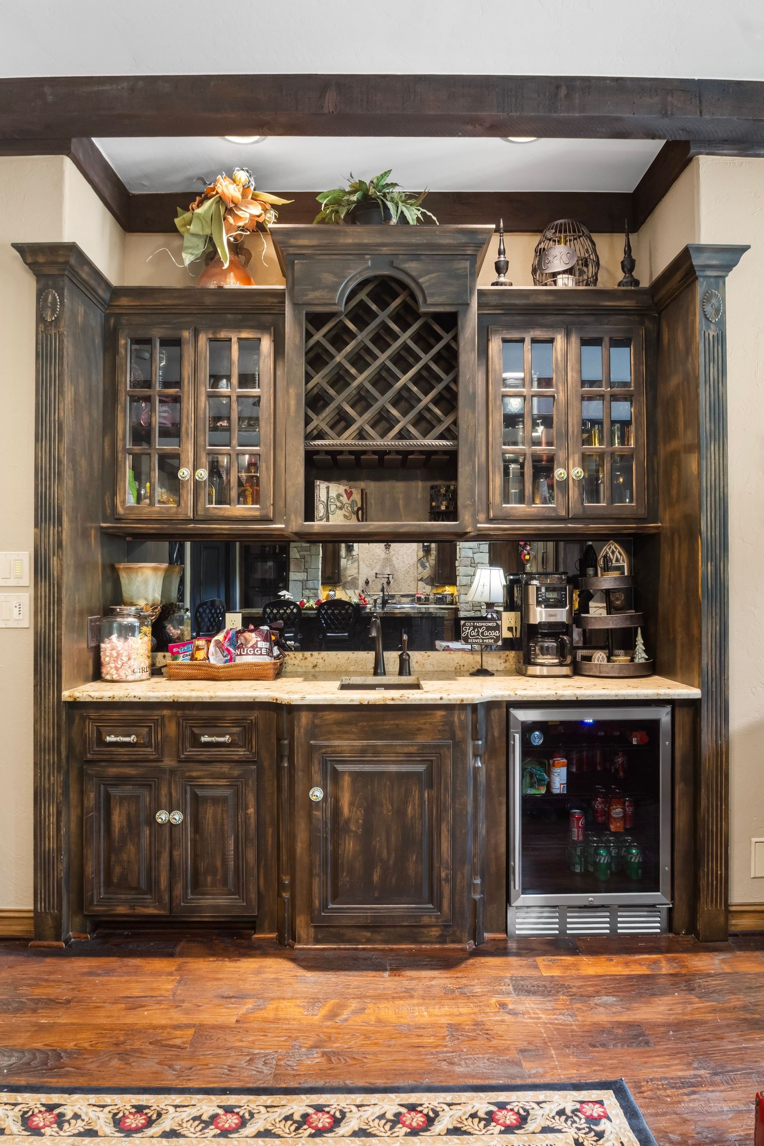 Custom built-in bar with dark wood cabinets, wine storage, and glass-front display cases.