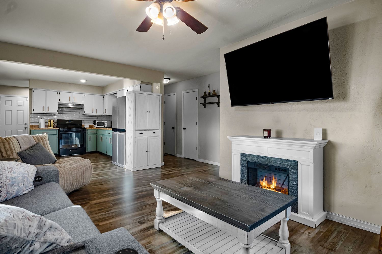 Modern living room interior with hardwood floors, ceiling fan, and recessed lighting.