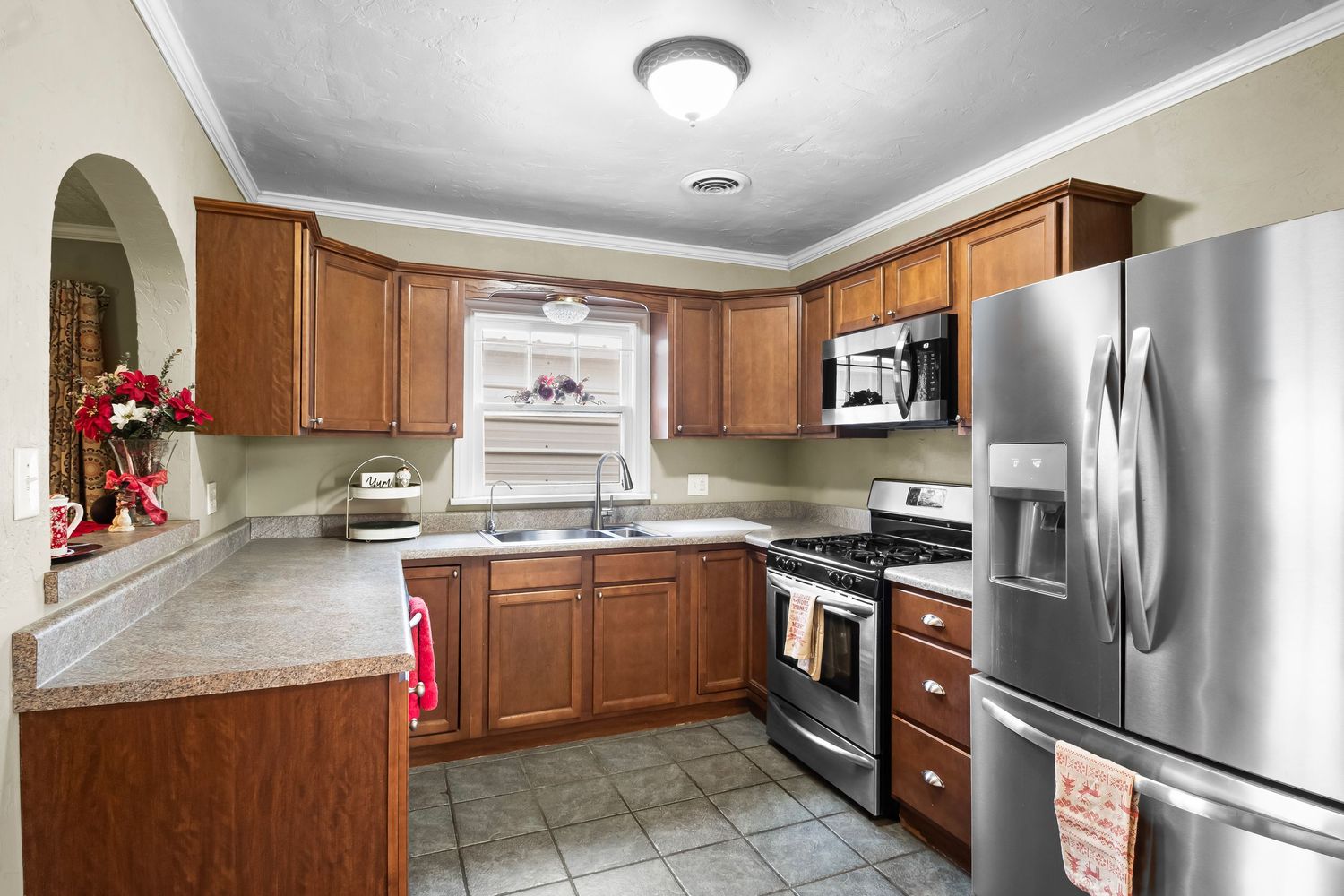 Updated kitchen with wood cabinets, stainless steel appliances, and granite countertops.