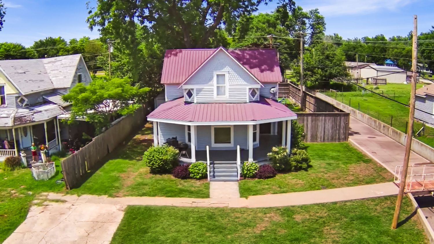 Panoramic aerial view of residential neighborhood with houses and green lawns.