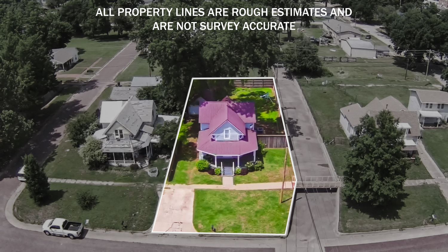 Aerial property view with highlighted lot boundaries showing a house with pink roof and landscaped yard.