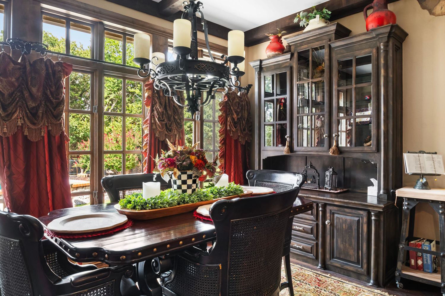 Dark wood kitchen with gothic-style cabinetry and pendant lighting over counter seating.
