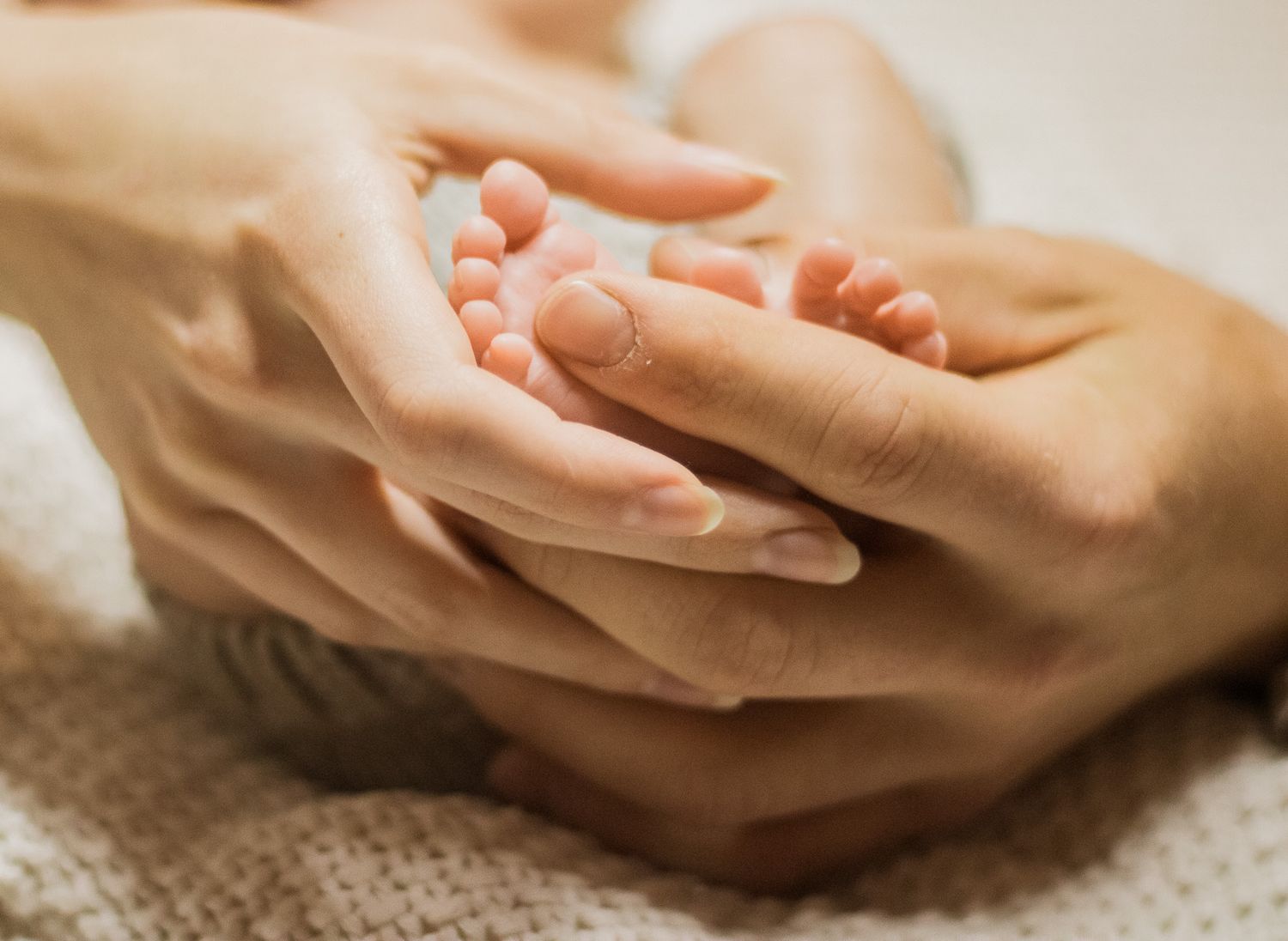Close up sequence of hands gently holding and caressing each other on a textured surface.
