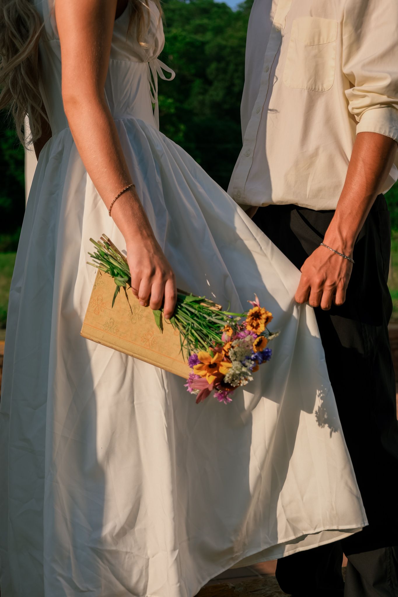 A series of photos showing hands holding small wildflower bouquets against a white dress in an outdoor setting.