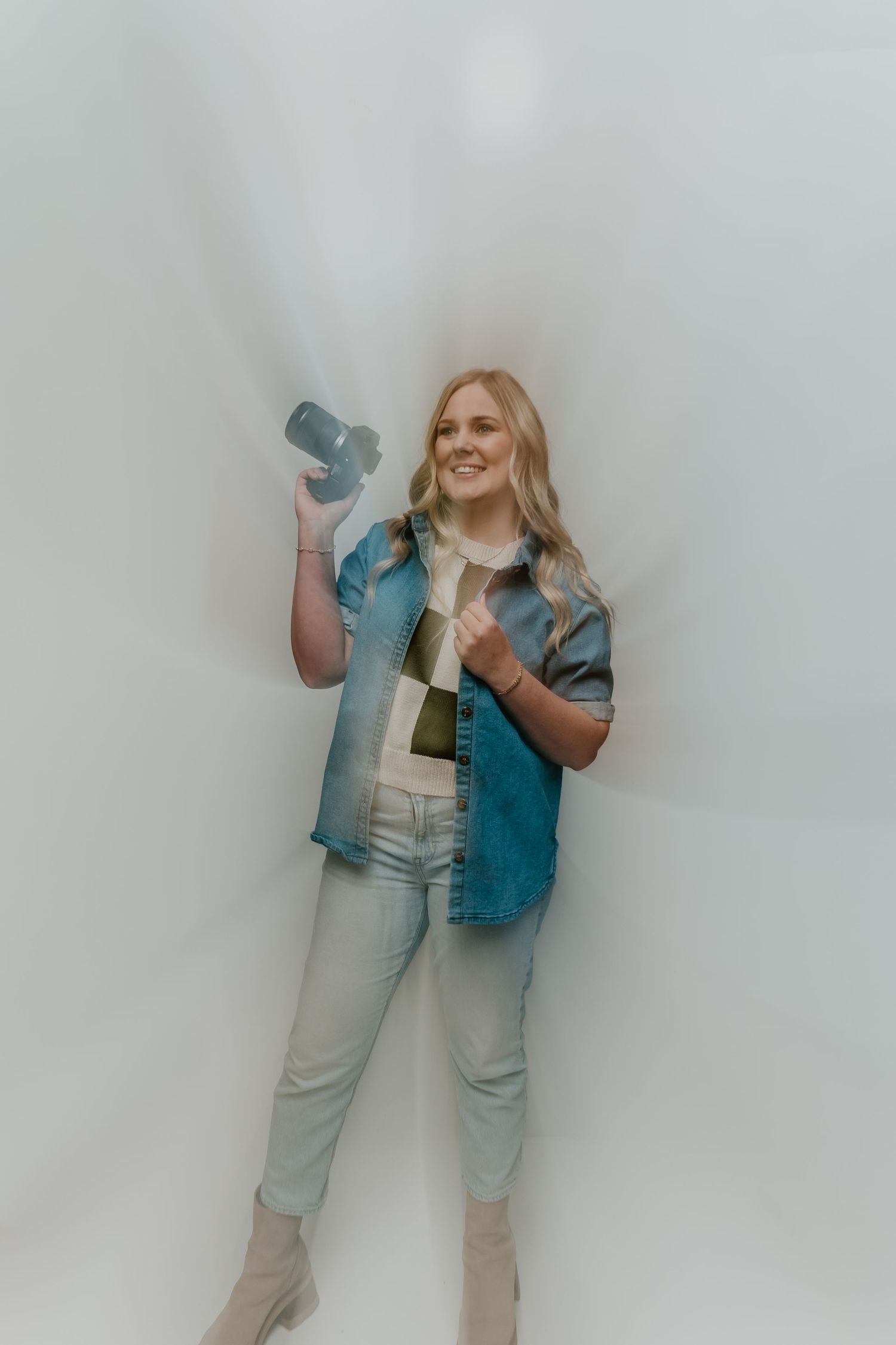 A person in a denim vest and light colored pants poses playfully against a white background in a photo series.
