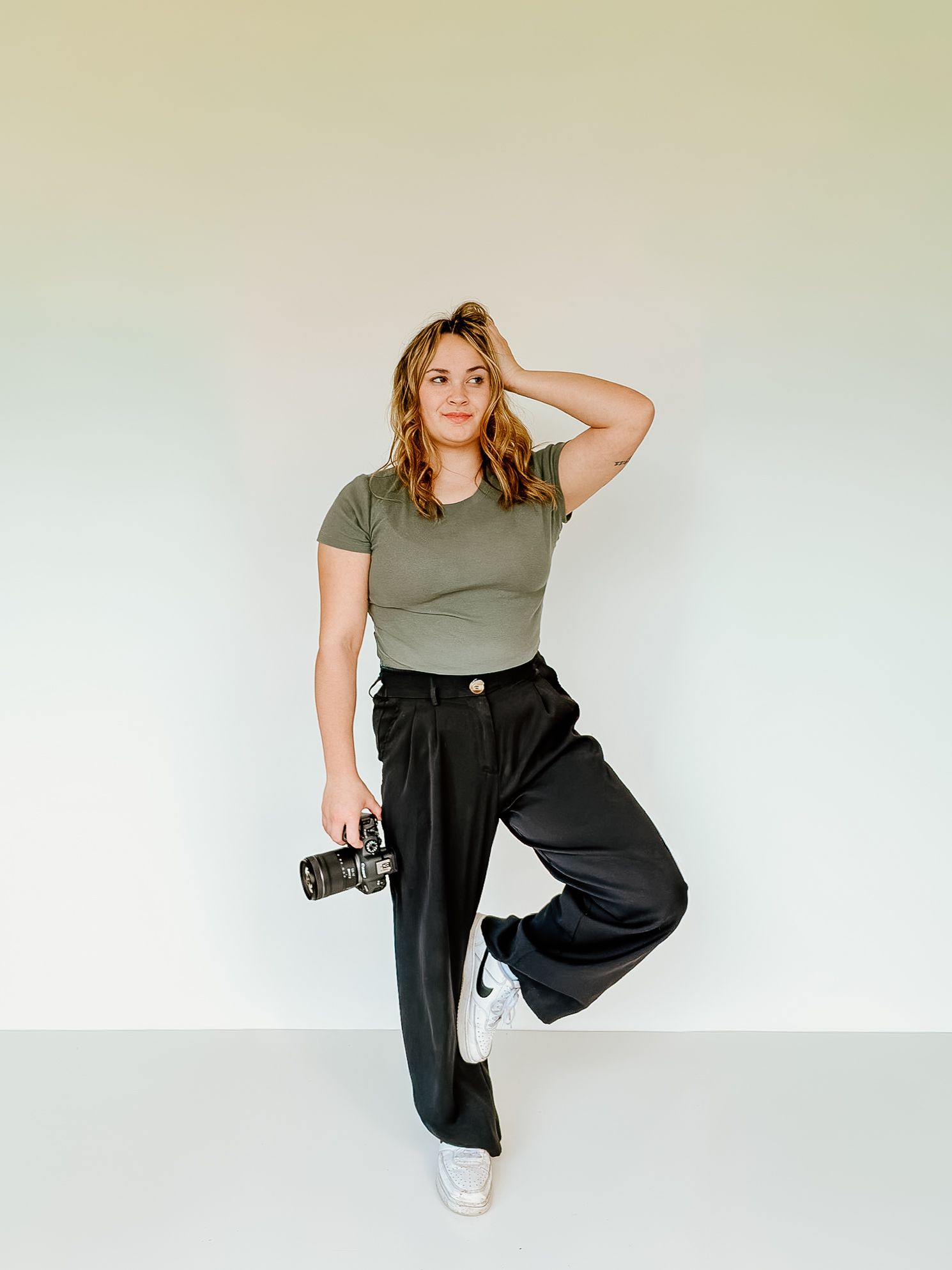 Hollie Elizzabeth, a West Virginia travel wedding and lifestyle photographer, posing playfully to showcase her personality and brand.