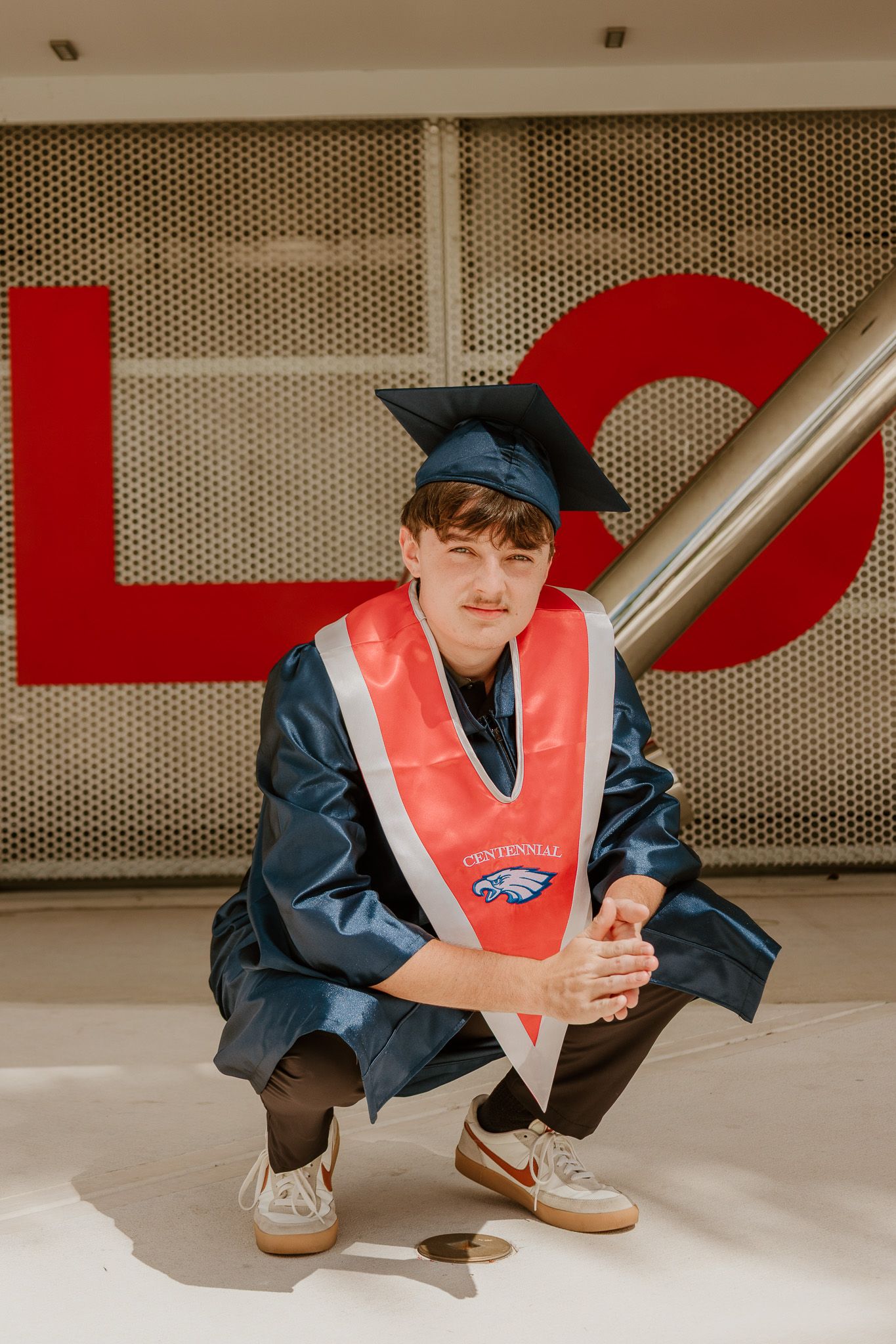 Person wearing a red safety vest and navy jacket crouches low to the ground in a repeating sequence of images.