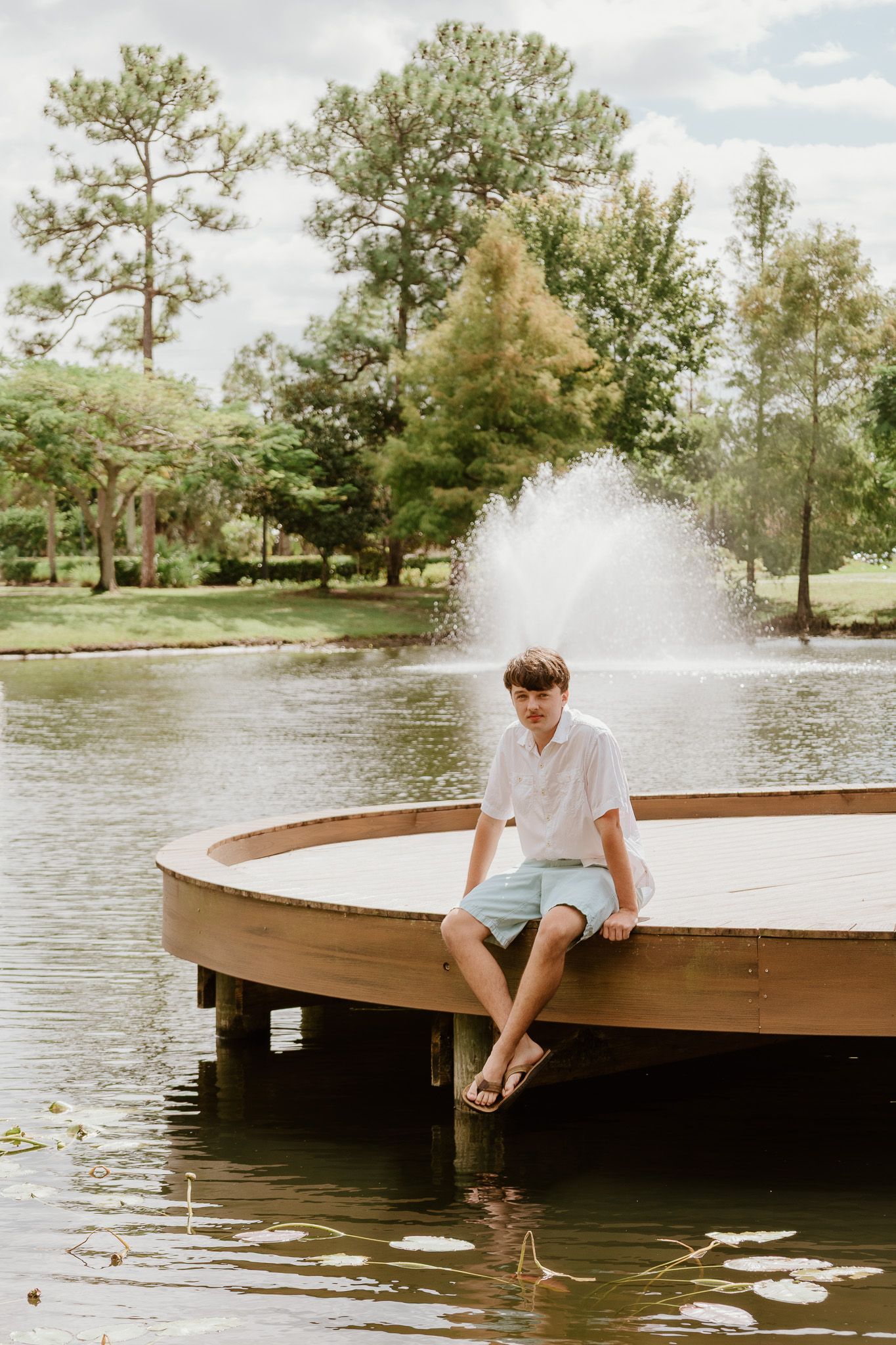 A sequence of photos showing someone sitting on a wooden dock by a lake with a fountain.