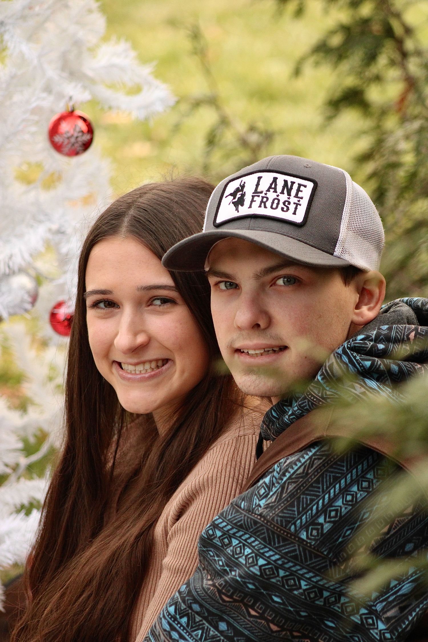 A couple shares intimate moments in a series of outdoor photos with apple trees and autumn scenery in the background.