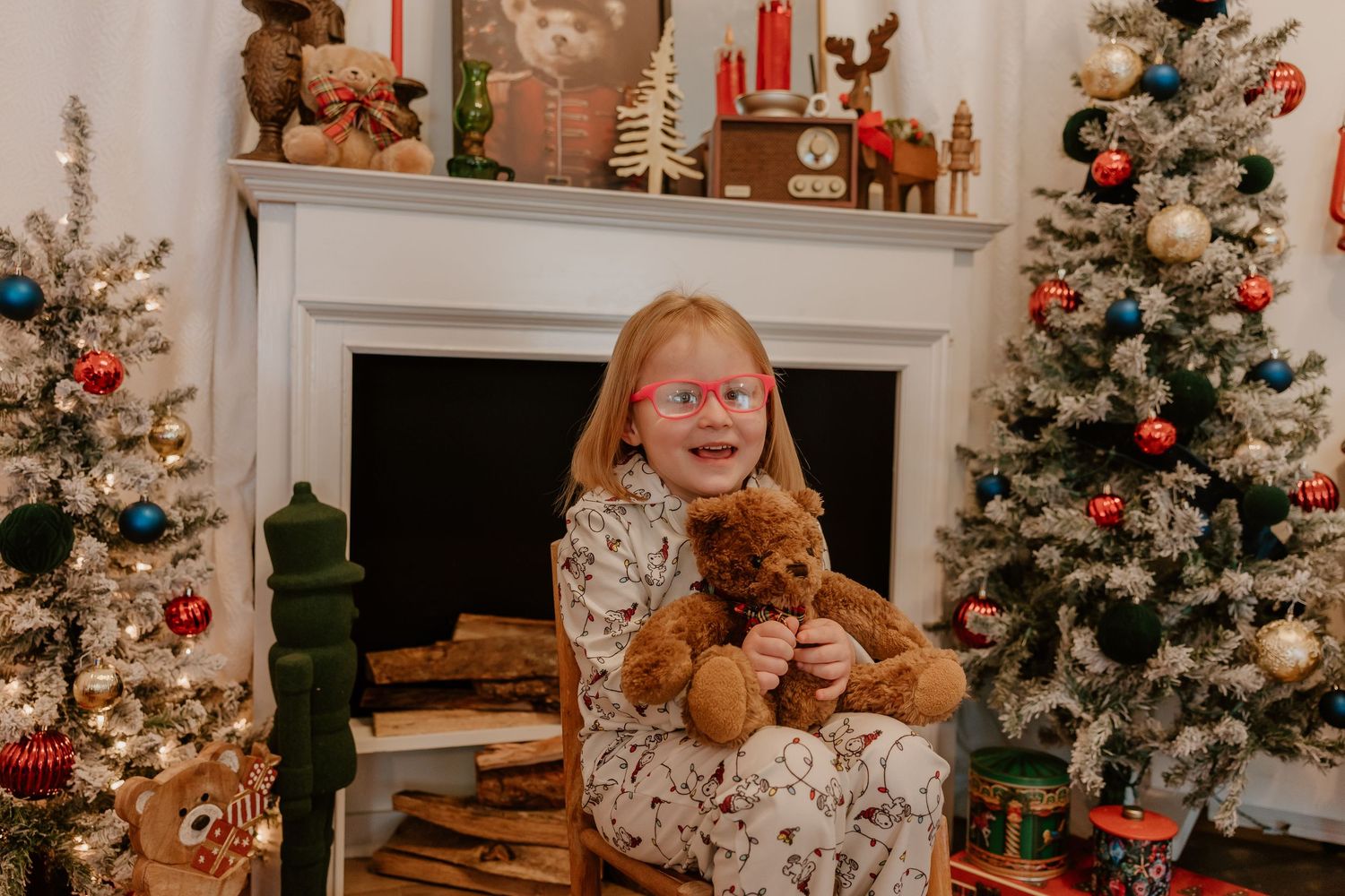 A cozy Christmas scene with decorated trees, teddy bears, and glowing holiday lights in a warm living room setting.