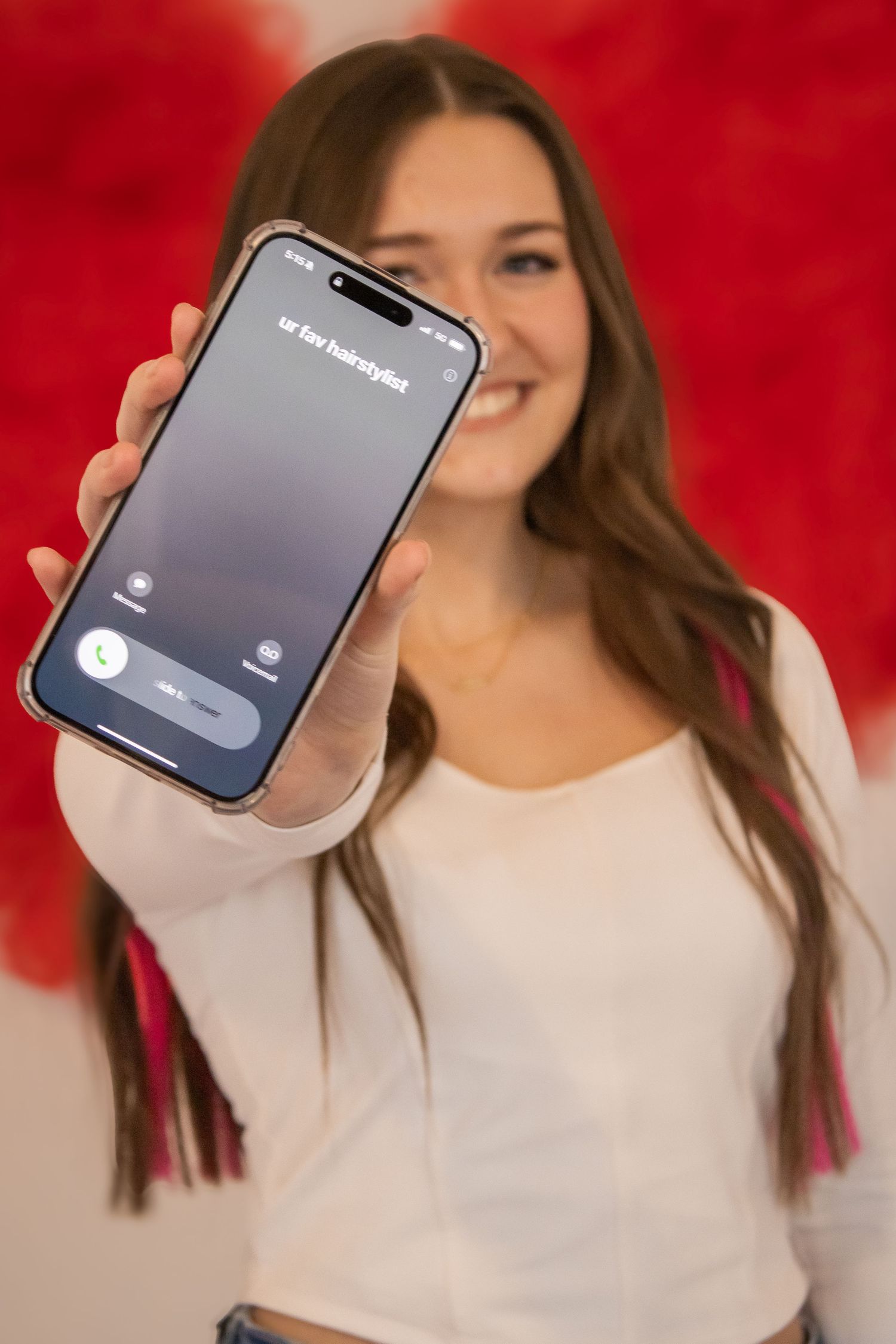 Person in white top holds iPhone showing login screen against red background in sequence of similar shots.