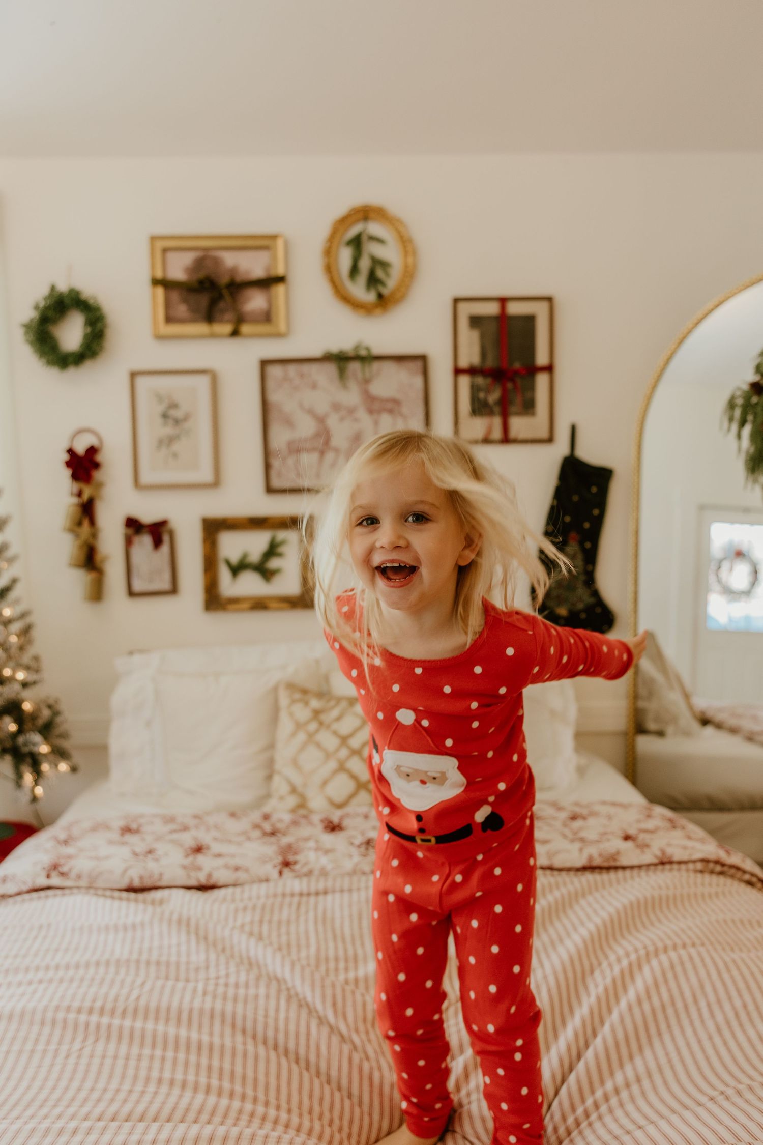 A series of photos showing a child in red polka dot pajamas jumping and playing on a bed with holiday decor visible.