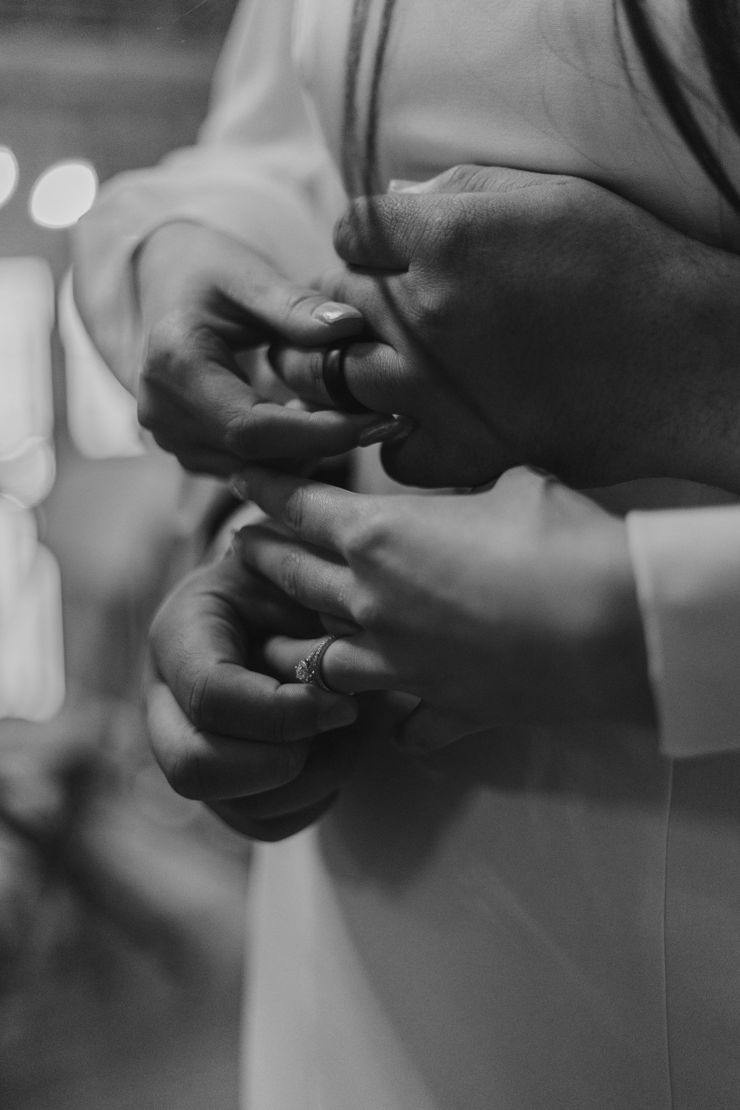 A series of black and white photos showing hands exchanging a wedding ring during a marriage ceremony.