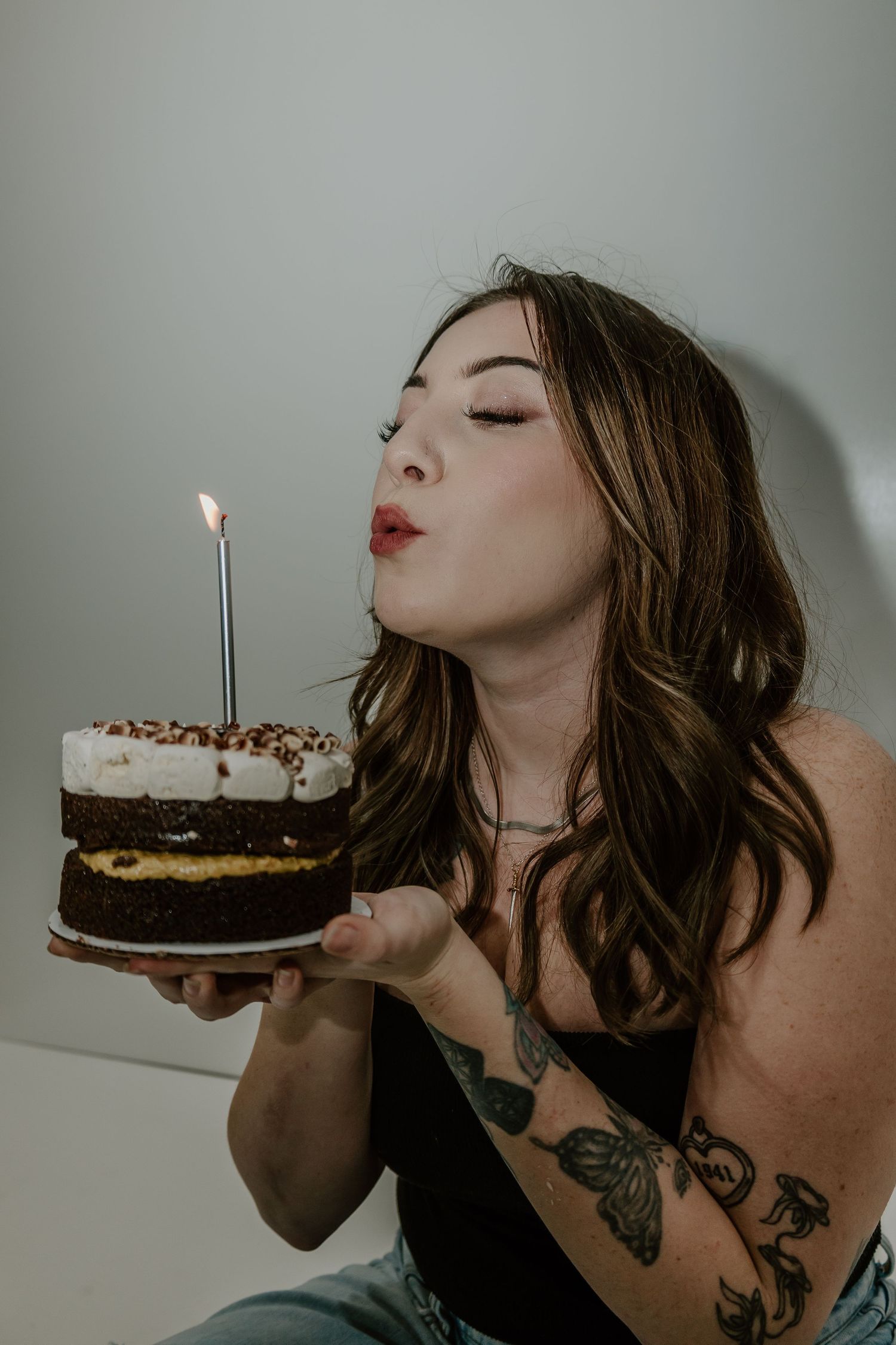 A sequence of photos showing someone blowing out a candle on a chocolate birthday cake.