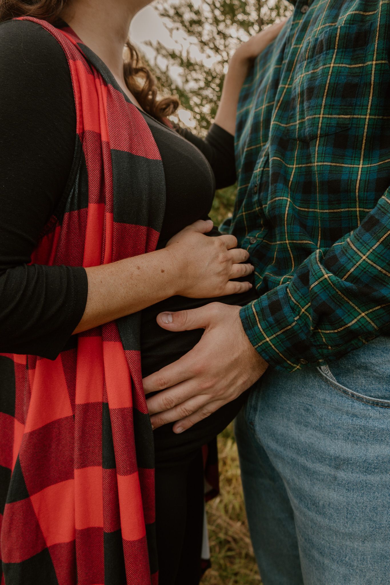 A couple wearing red buffalo plaid and green plaid shirts embrace in a romantic series of close-up shots.