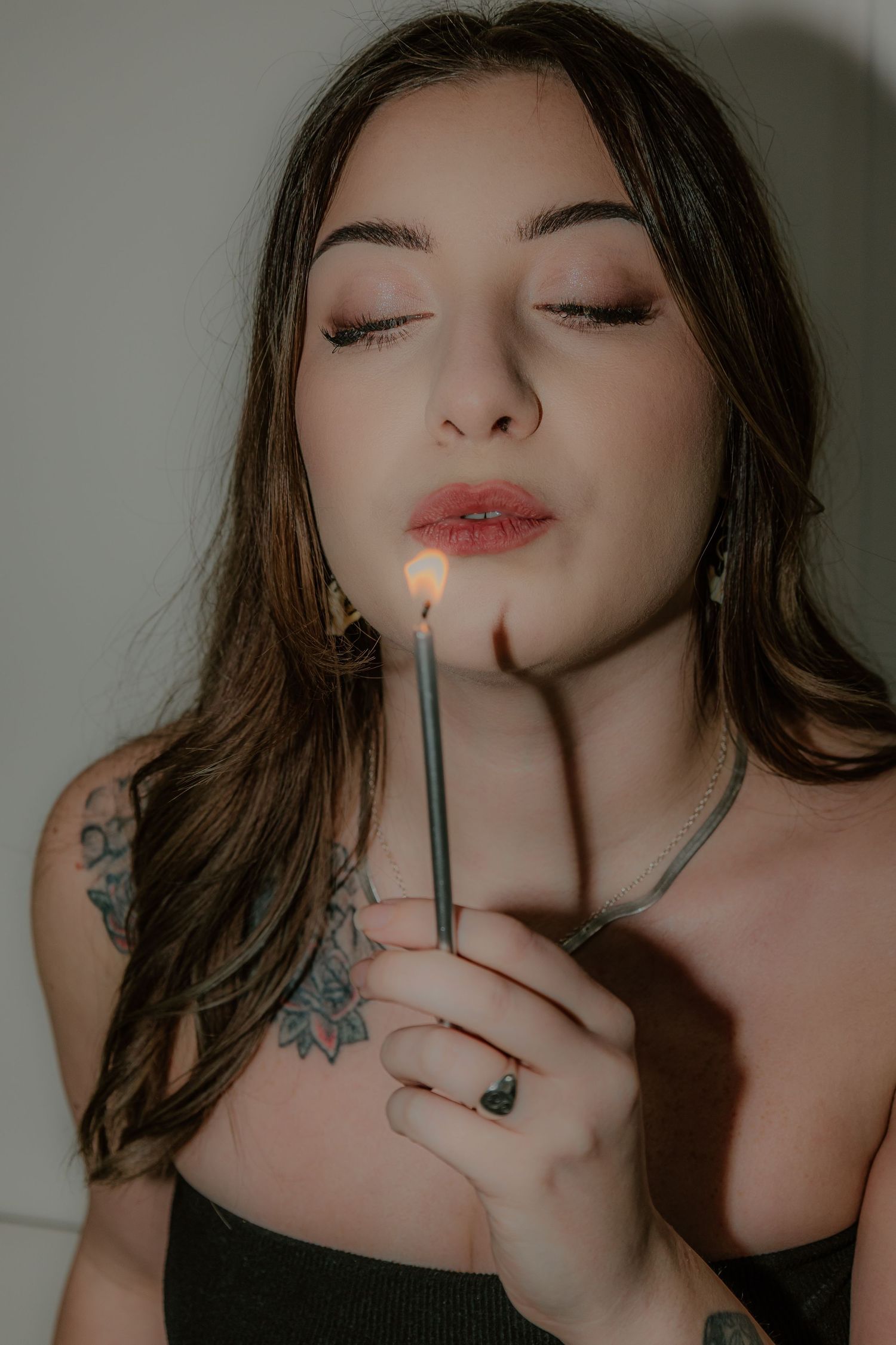 Close-up artistic photo series showing a person with dark hair holding a cigarette in moody lighting.