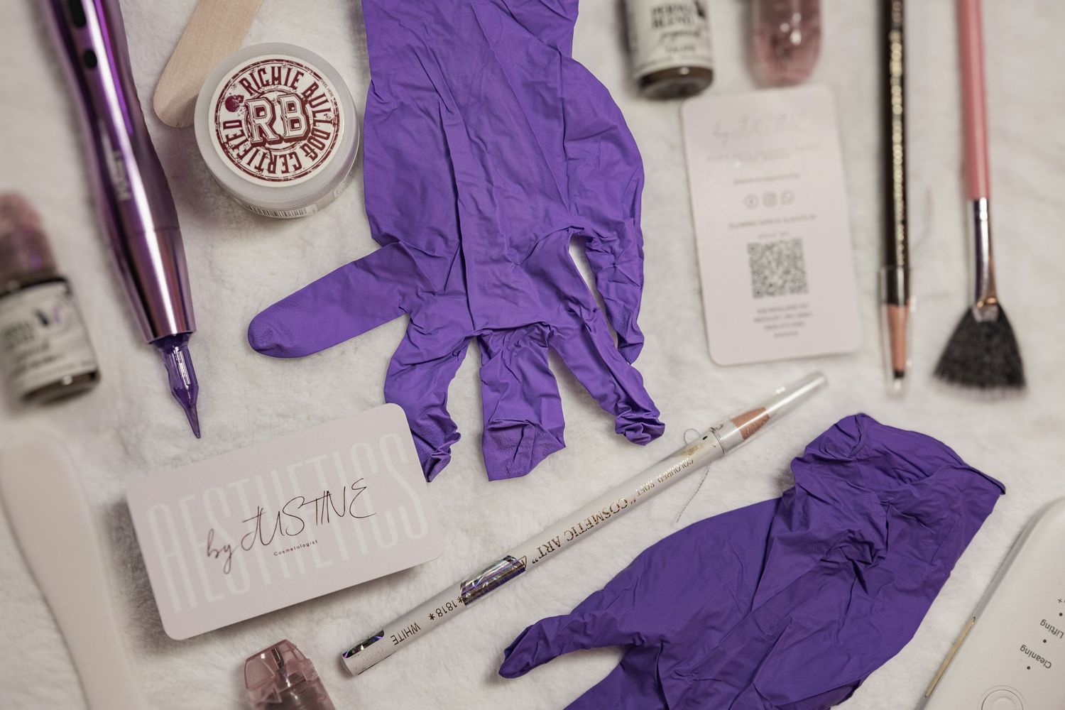 Purple latex gloves arranged on a white surface with medical supplies and paperwork visible in the background.