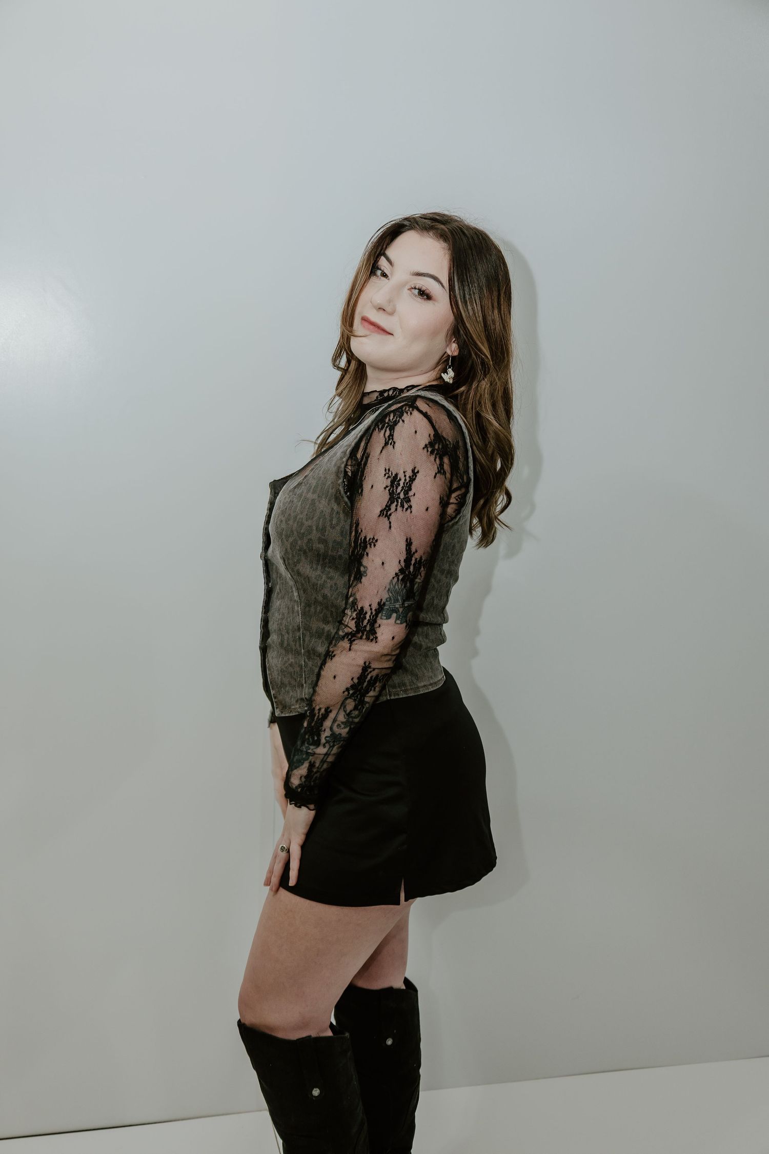 Fashion photo series showing model in black lace and grey against neutral backdrop posing in four artistic shots.