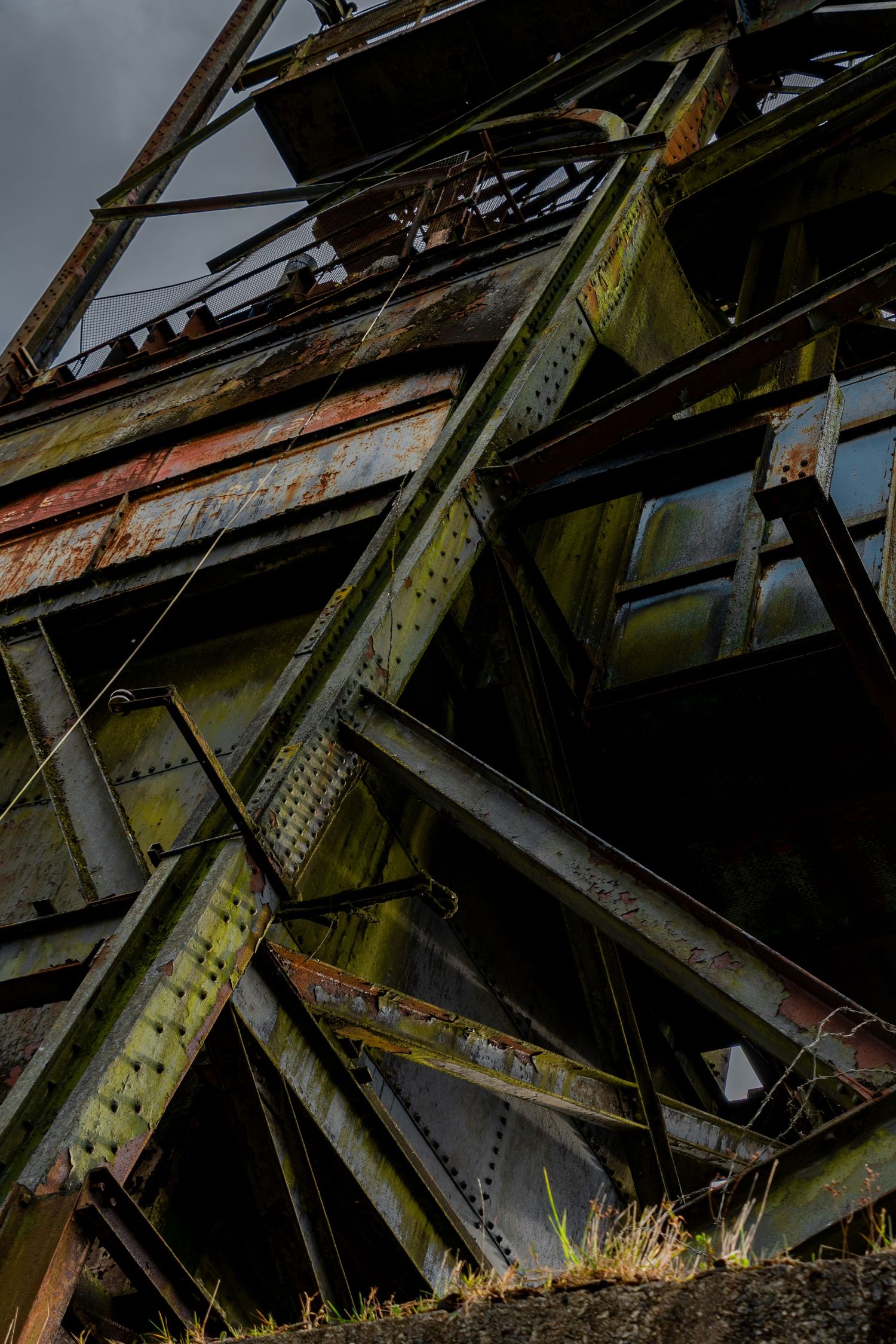 Penallta Colliery Wales. Ash Olion
Close-up of a rusted steel industrial headstock, with criss-crossing beams, weathered metal panels,