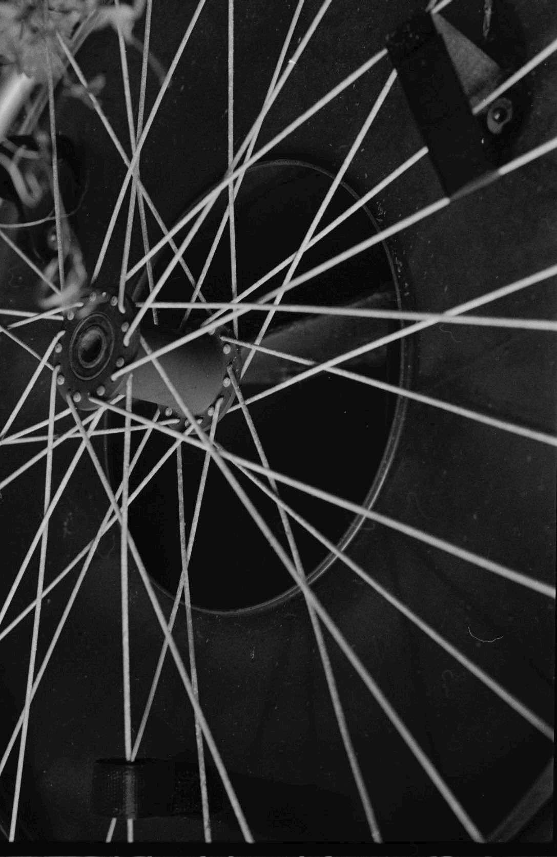 black and white close up of a bicicle wheel on 35 mm film. high contrast. ash olion photography
